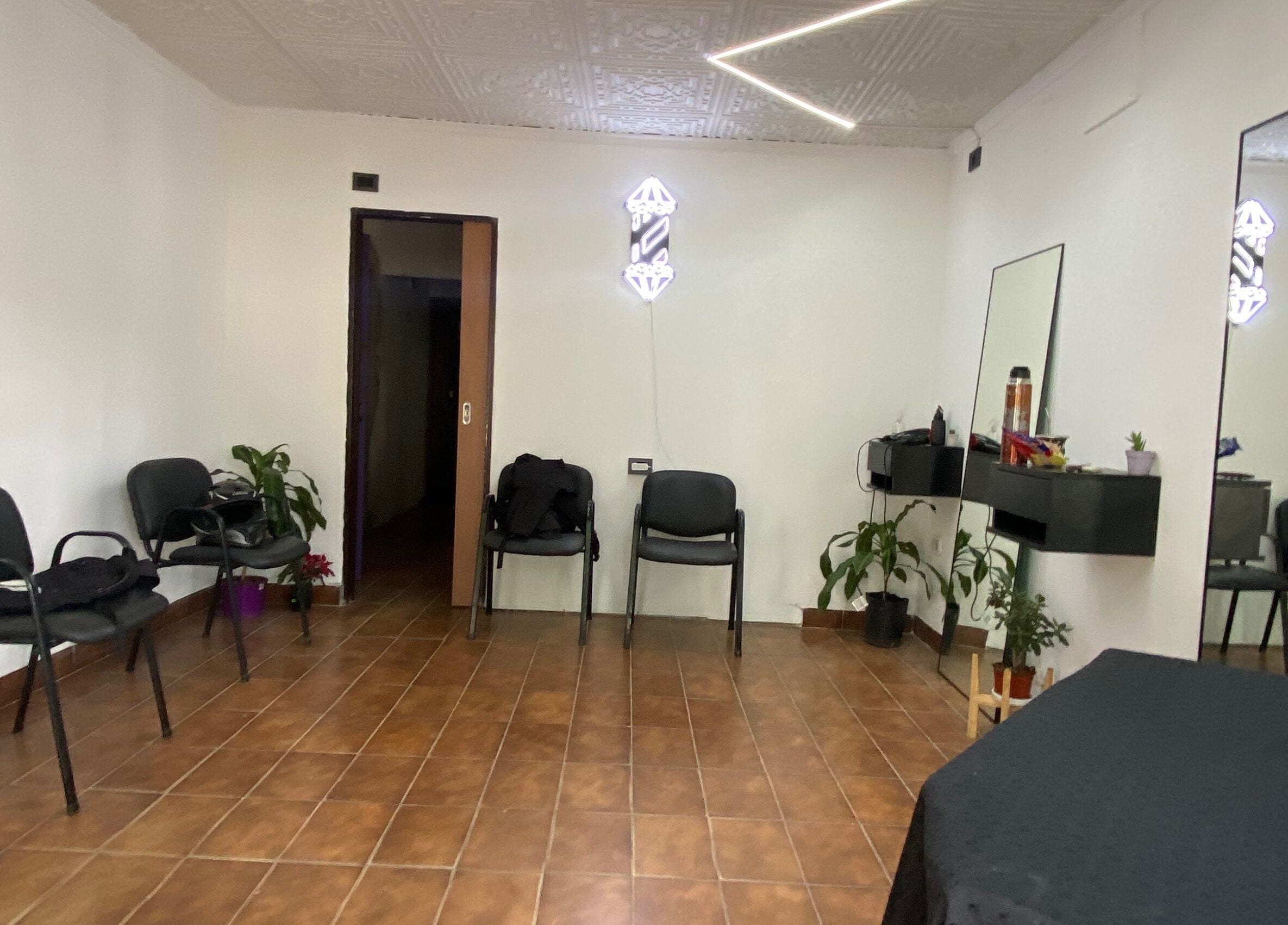 Interior moderno de Vortex Hairstudio en Rosario, Santa Fe, AR con decoración minimalista y cómodo mobiliario.