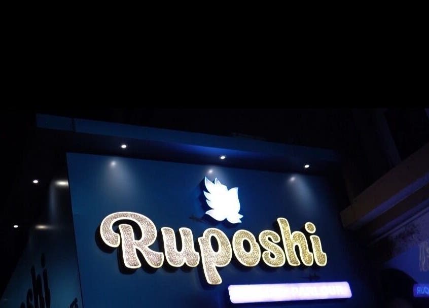 Luminous Ruposhi Beauty Parlour sign in Kolkata, West Bengal, IN, glowing at night.