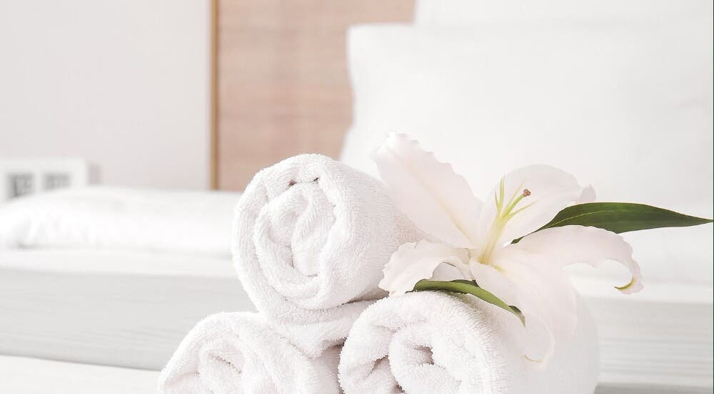 Elegant rolled towels with a flower at Warch Airbnb Care, Coolangatta, Queensland, AU.