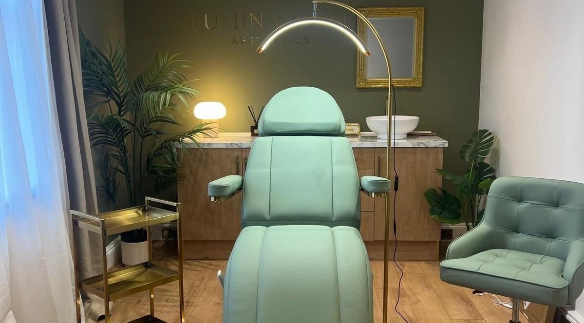 Luxurious treatment room at Lumina Viso in Wokingham, England, GB with green chair, lamp, and decor.