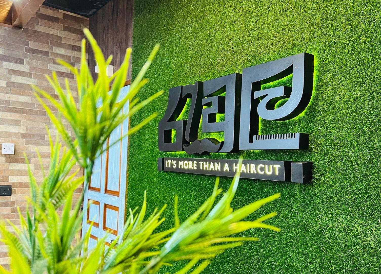 Vibrant interior of Raula Barbershop Baseline Road, Colombo, Western Province, LK featuring lush greenery and signage.