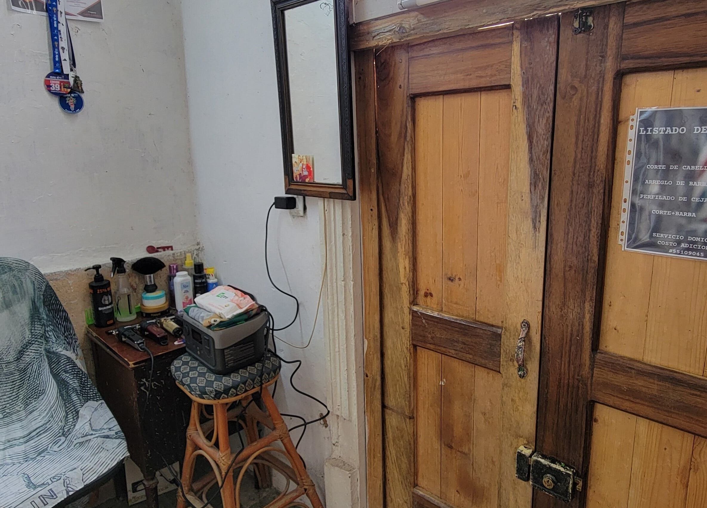 Interior rústico de La Roca Barbería en La Habana, CU, con silla y herramientas de barbería.