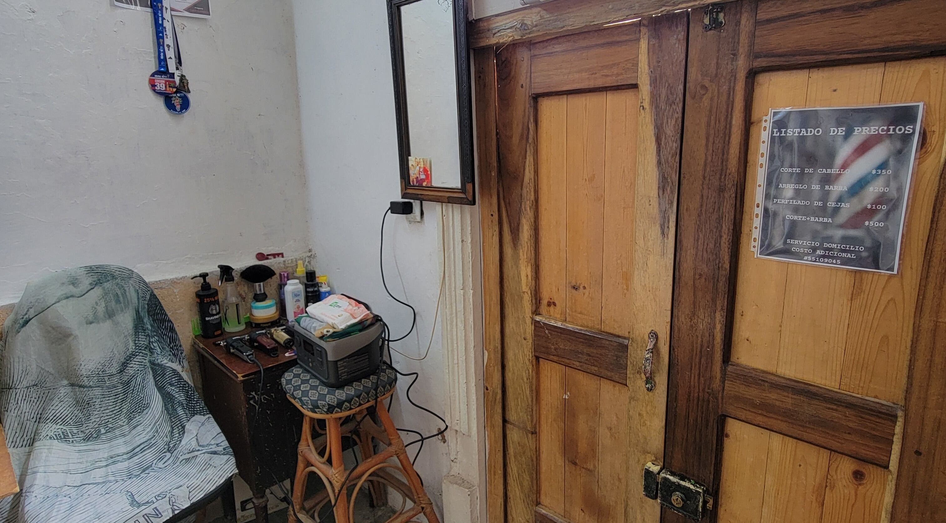 Interior rústico de La Roca Barbería en La Habana, CU, con silla y herramientas de barbería.