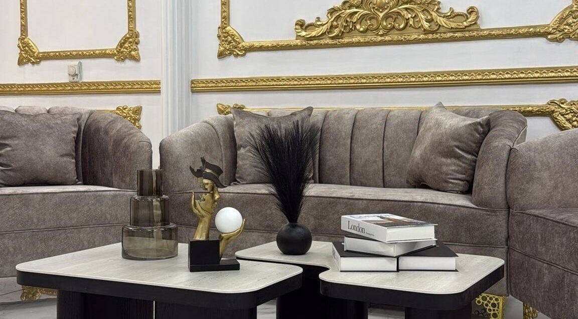 Luxurious lounge area at Stellar Beauty in Doha, Doha Municipality, QA with plush sofas and golden accents.
