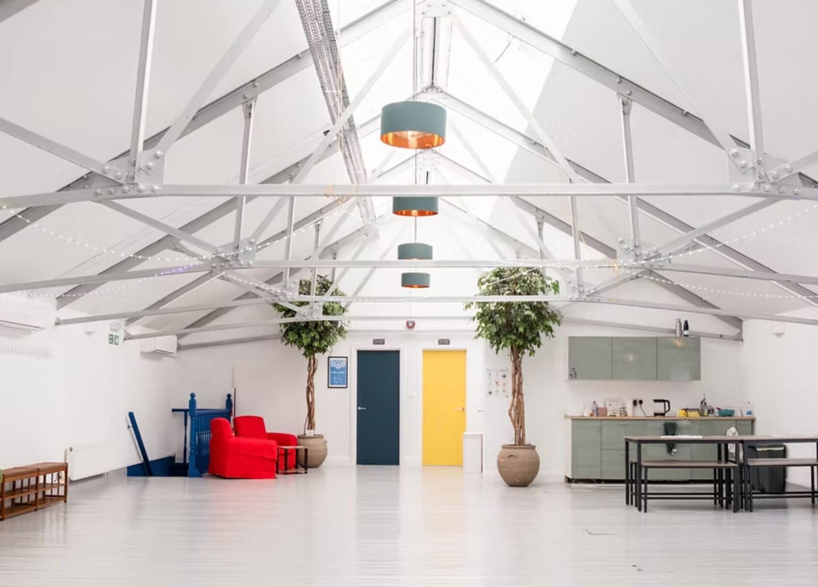 Bright interior with high ceiling and plants at Venus Holistic Therapies at Prana Voice, London, England, GB.