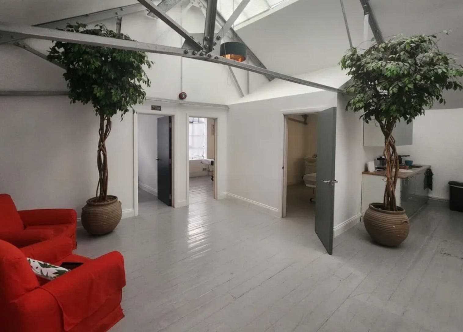 Serene waiting area at Venus Holistic Therapies at Prana Voice, London, England, GB with cozy red chairs.