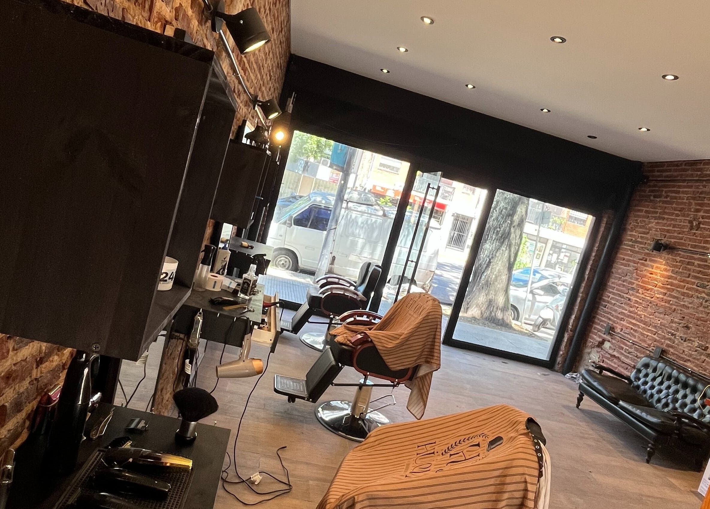 Interior de HÜOMO BARBIERE CLUB en Buenos Aires, Ciudad Autónoma De Buenos Aires, AR, con sillas y decoración moderna.