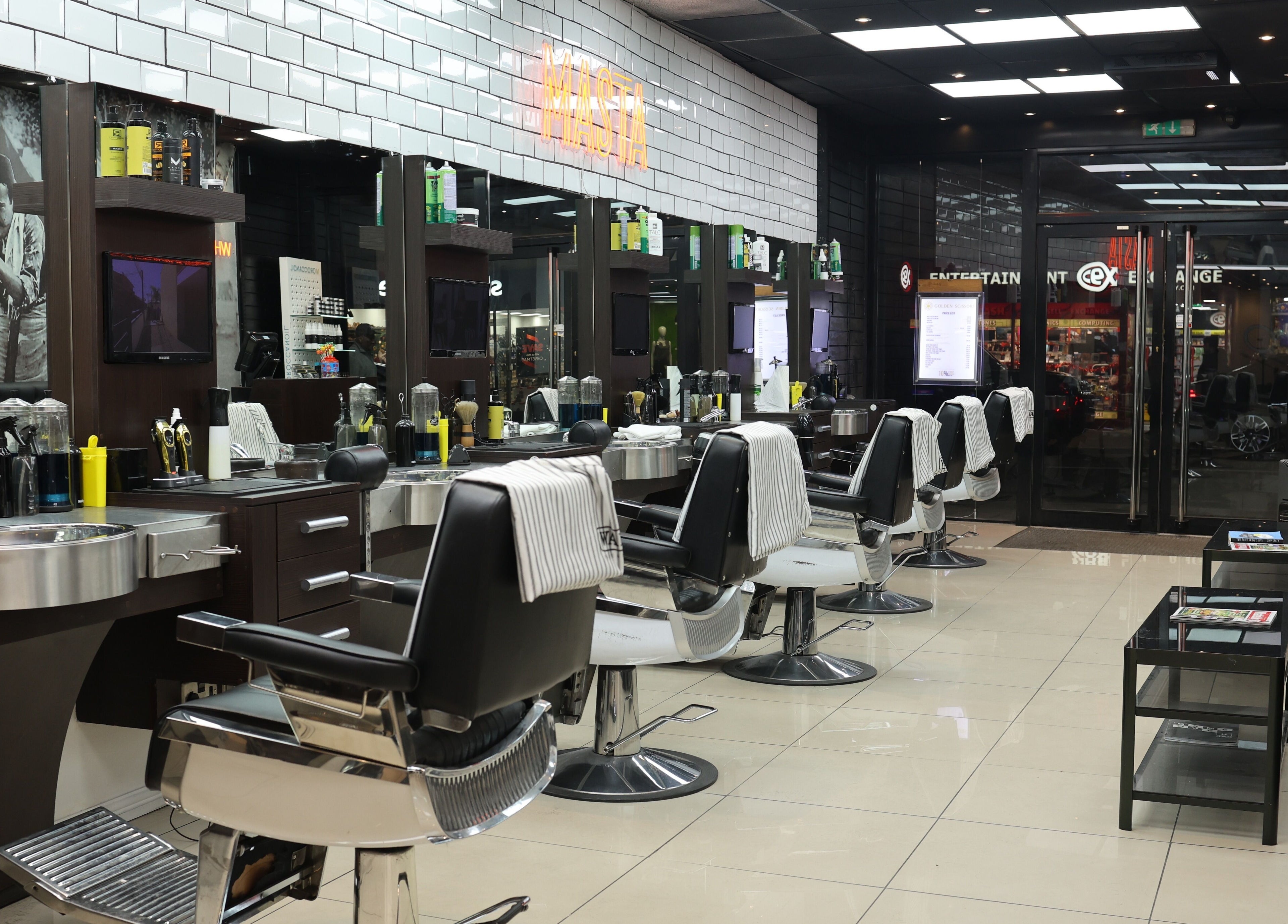 Modern interior of Golden Scissors in Birmingham, England, GB, with chic barber chairs and elegant decor.