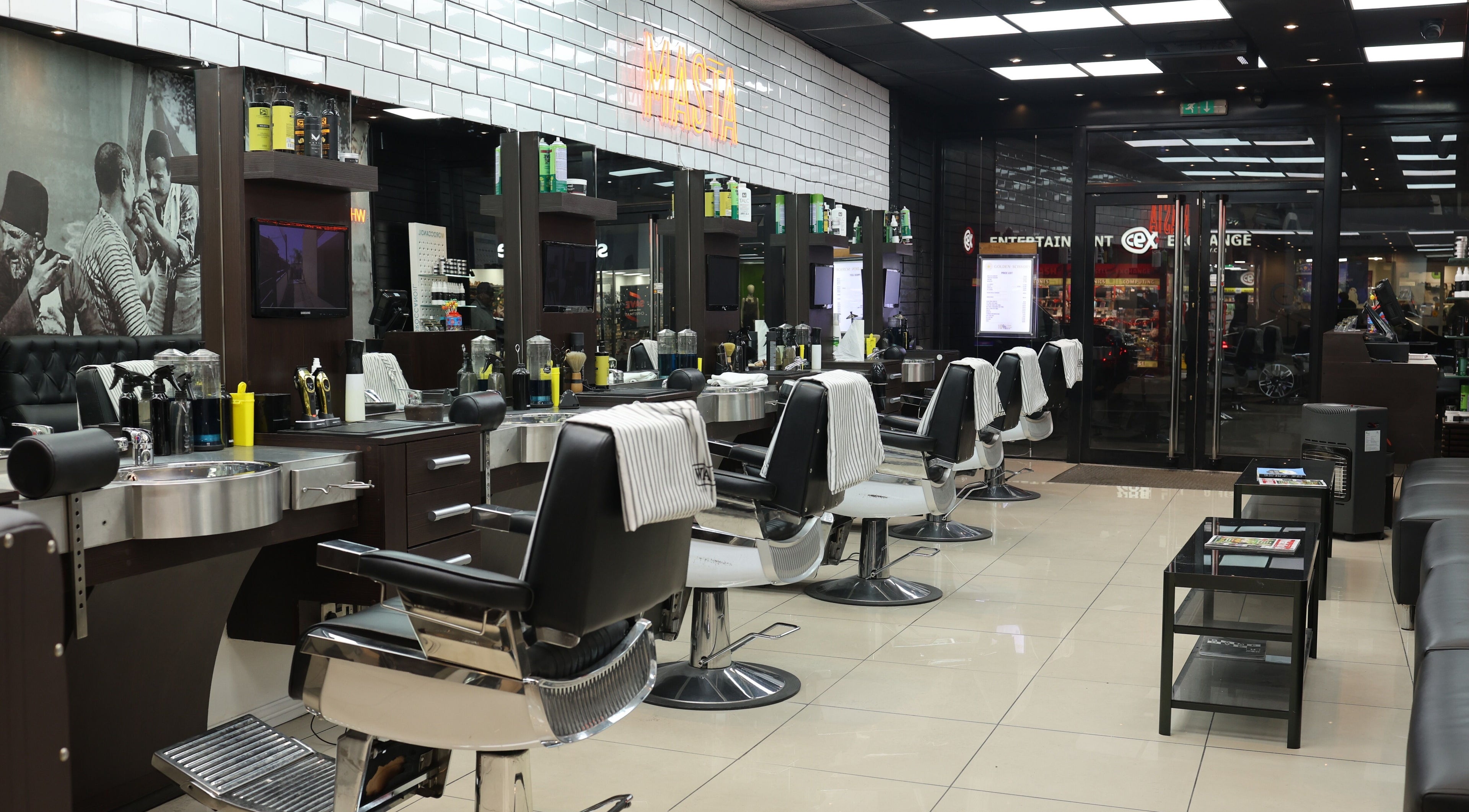 Modern interior of Golden Scissors in Birmingham, England, GB, with chic barber chairs and elegant decor.