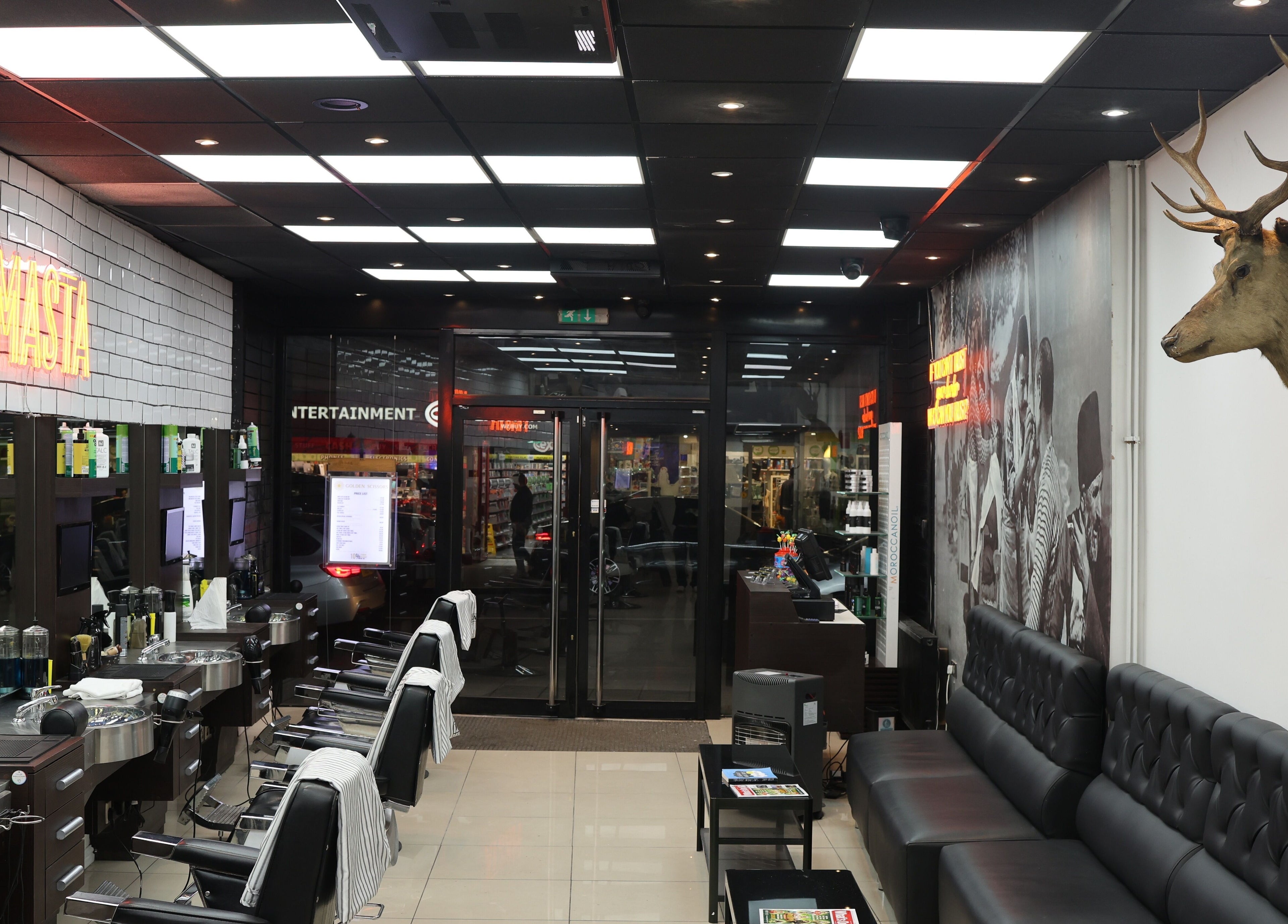 Interior of Golden Scissors in Birmingham, England, GB, featuring sleek barber chairs and modern decor.