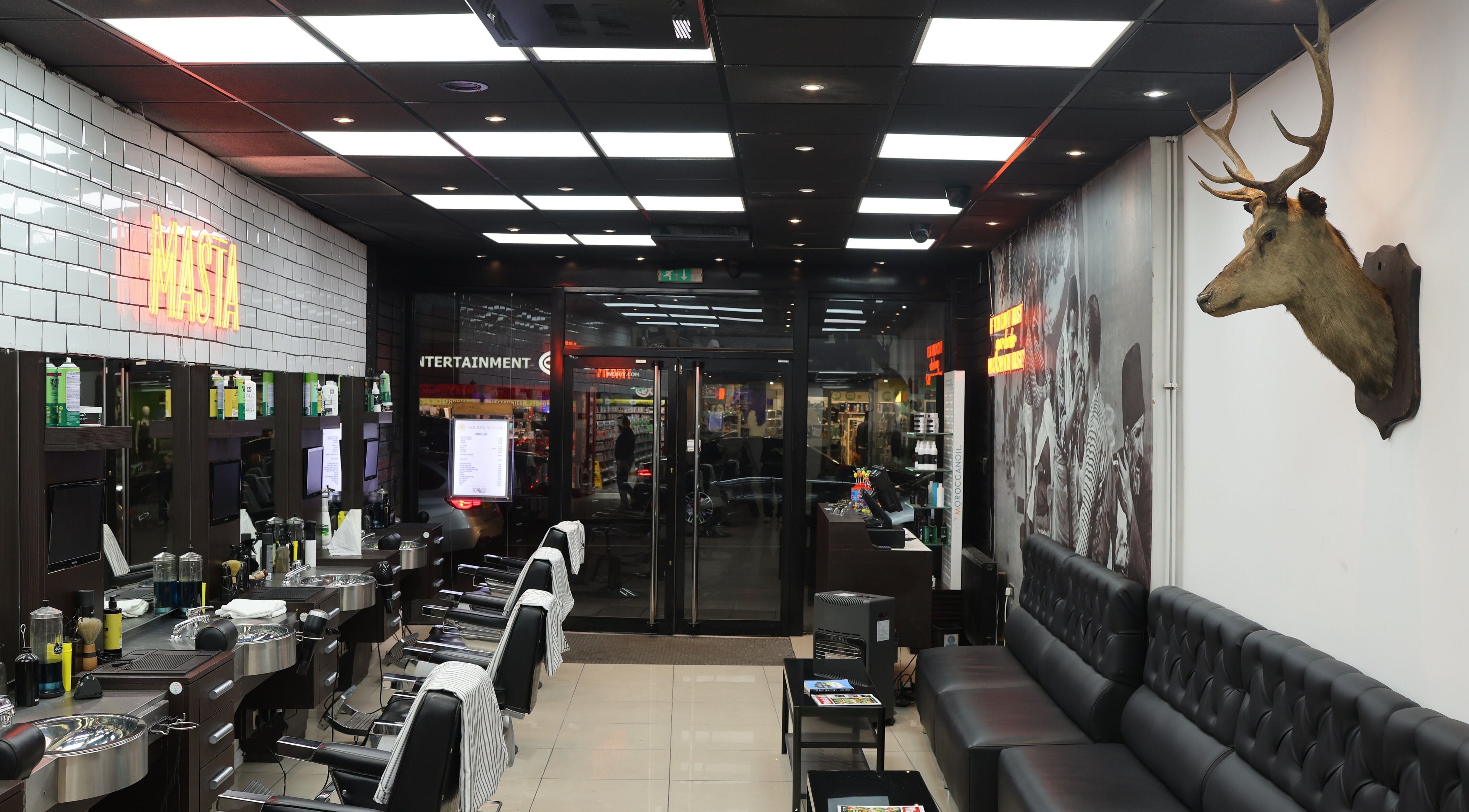 Interior of Golden Scissors in Birmingham, England, GB, featuring sleek barber chairs and modern decor.