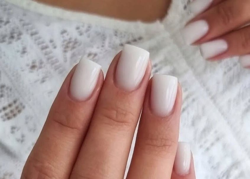 Elegancki manicure w Ipswich Nails, Ipswich, England, GB. Delikatne białe paznokcie na eleganckiej dłoni.