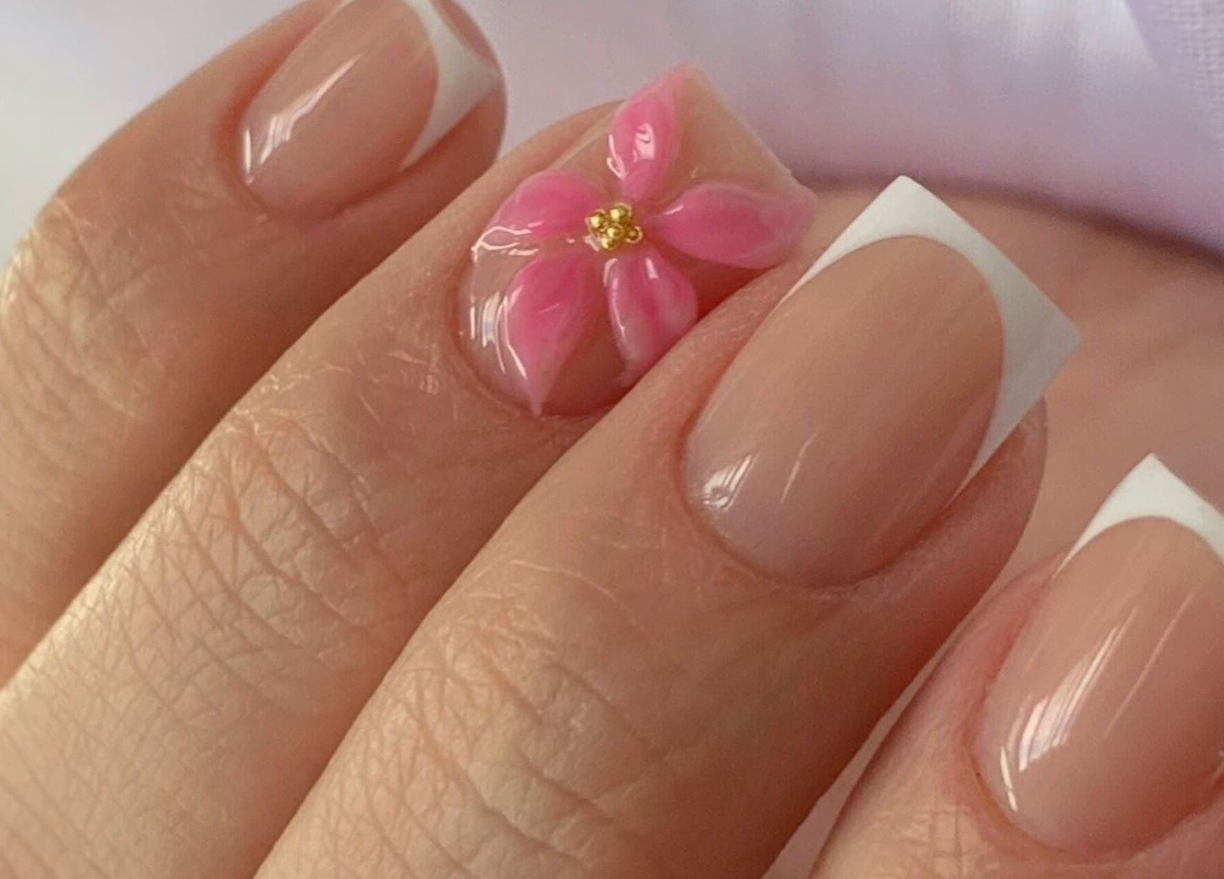 Hermoso diseño de uñas con flor rosa en LeslieStudio, Macul, Región Metropolitana, CL, destacando elegancia.