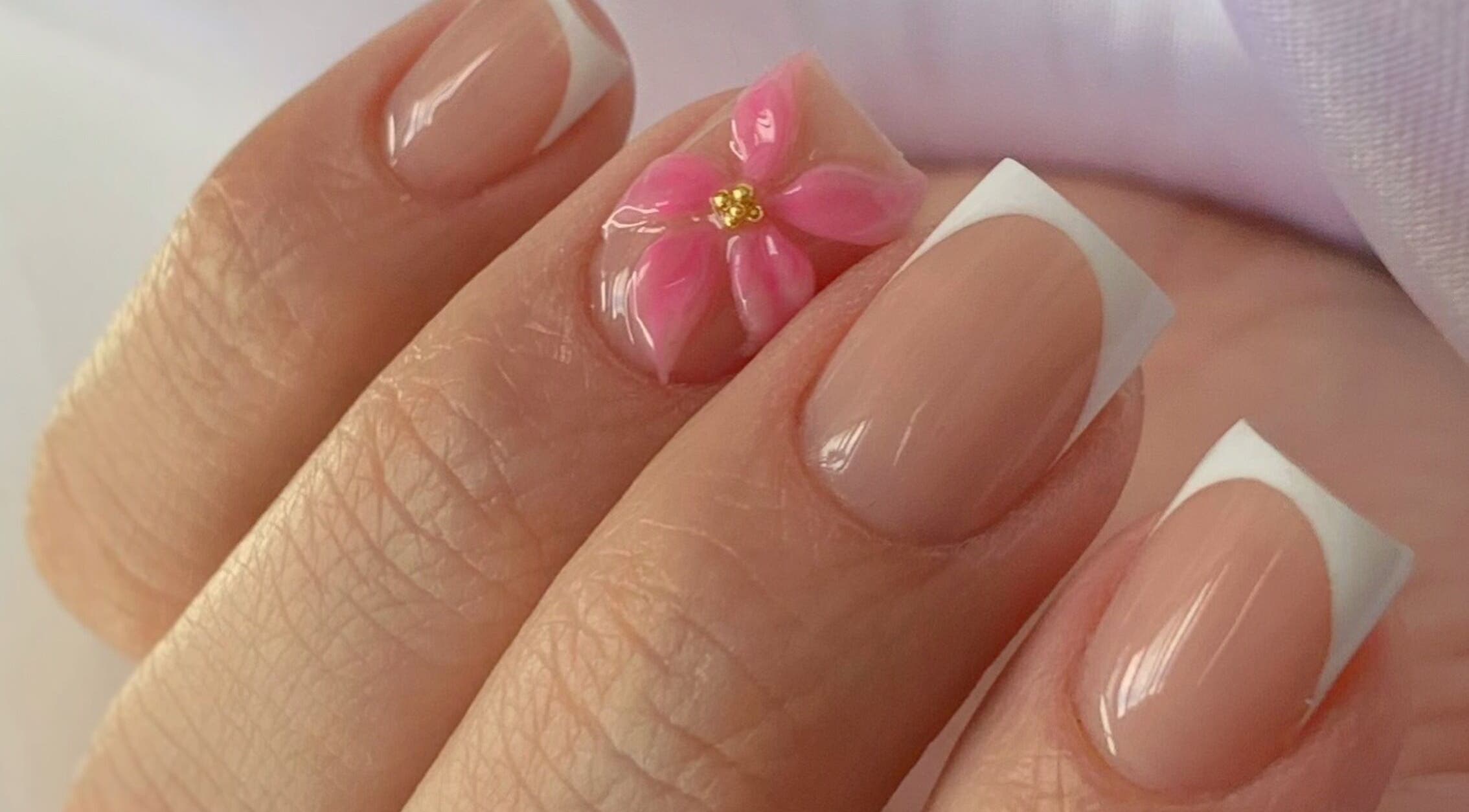 Hermoso diseño de uñas con flor rosa en LeslieStudio, Macul, Región Metropolitana, CL, destacando elegancia.