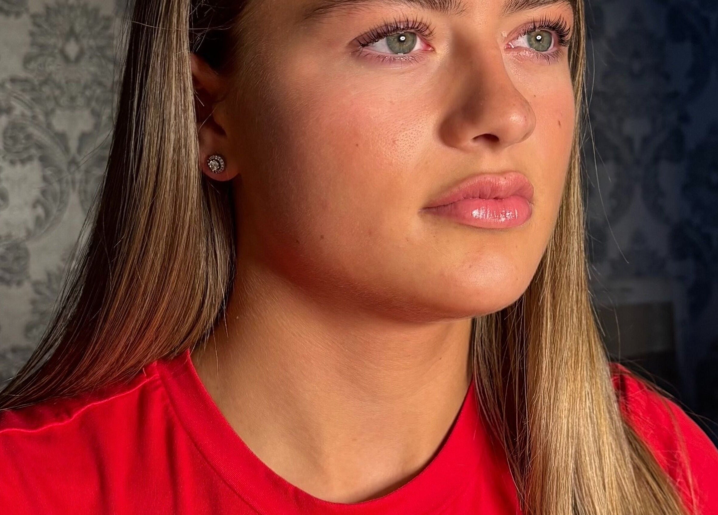 Close-up of a woman with glossy lips at Beautyblissbymia_ in London, England, GB; serene ambiance.