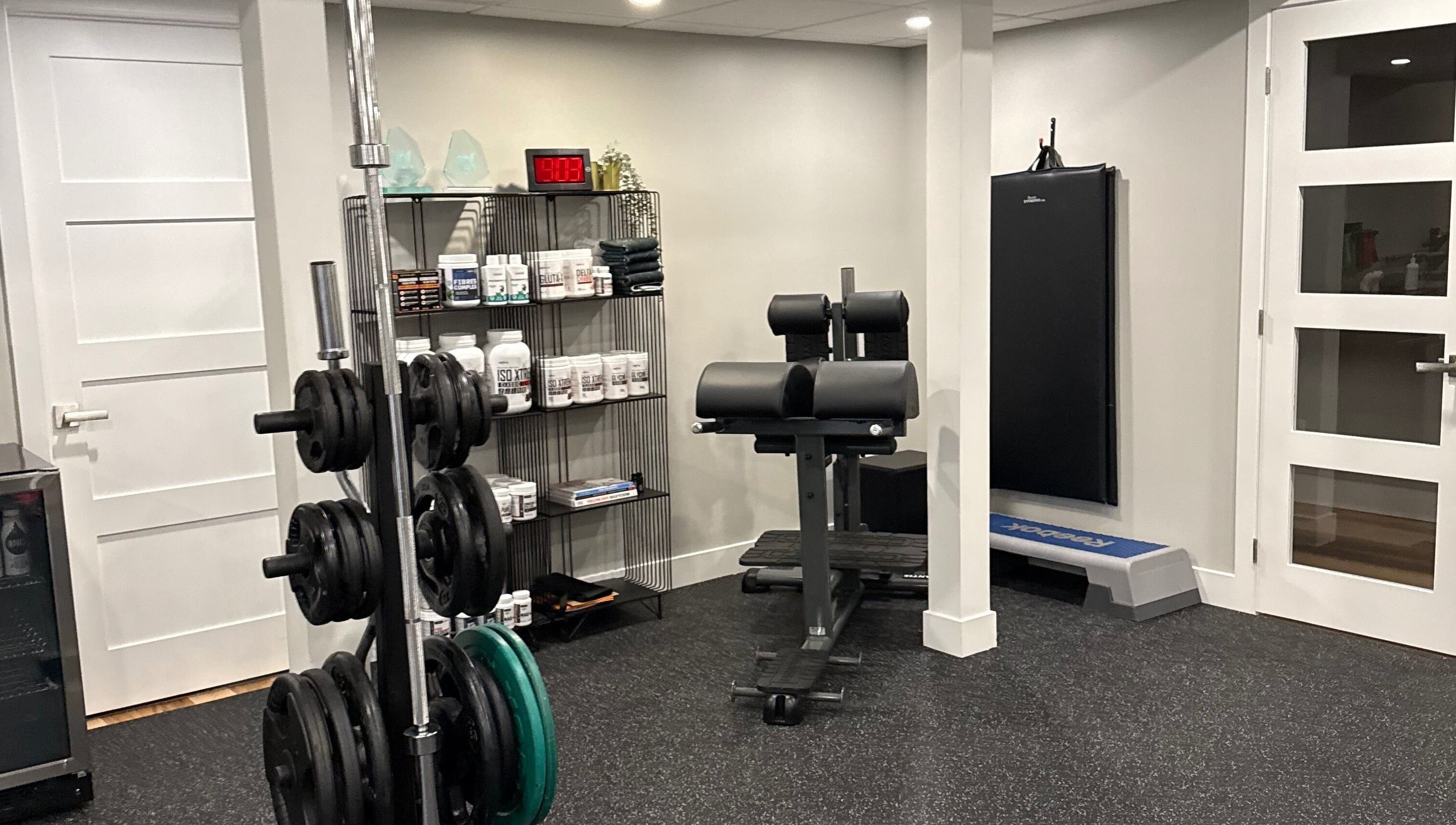 Gym area at Live avec Sylvia in Québec, CA featuring equipment and supplements for wellness.