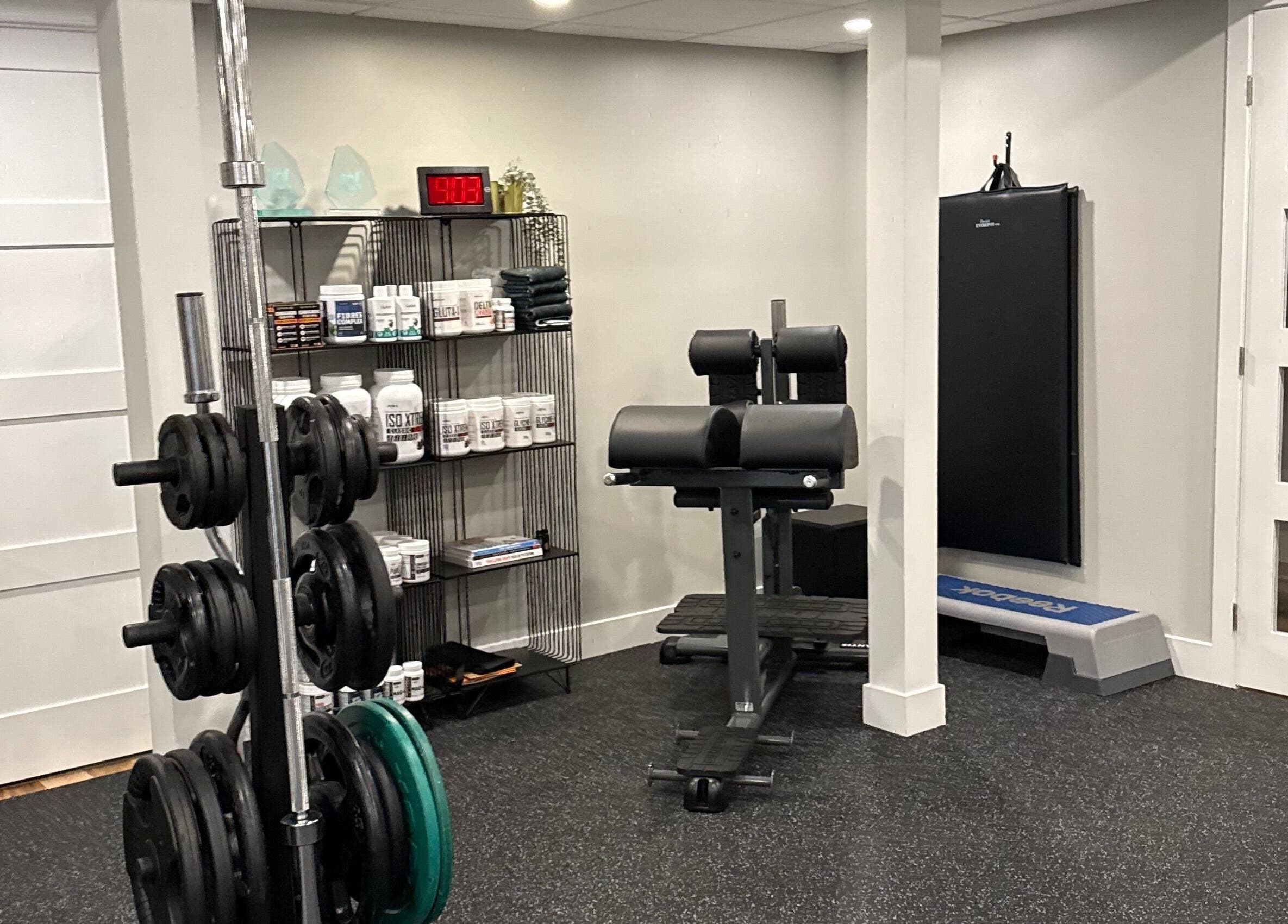 Gym area at Live avec Sylvia in Québec, CA featuring equipment and supplements for wellness.