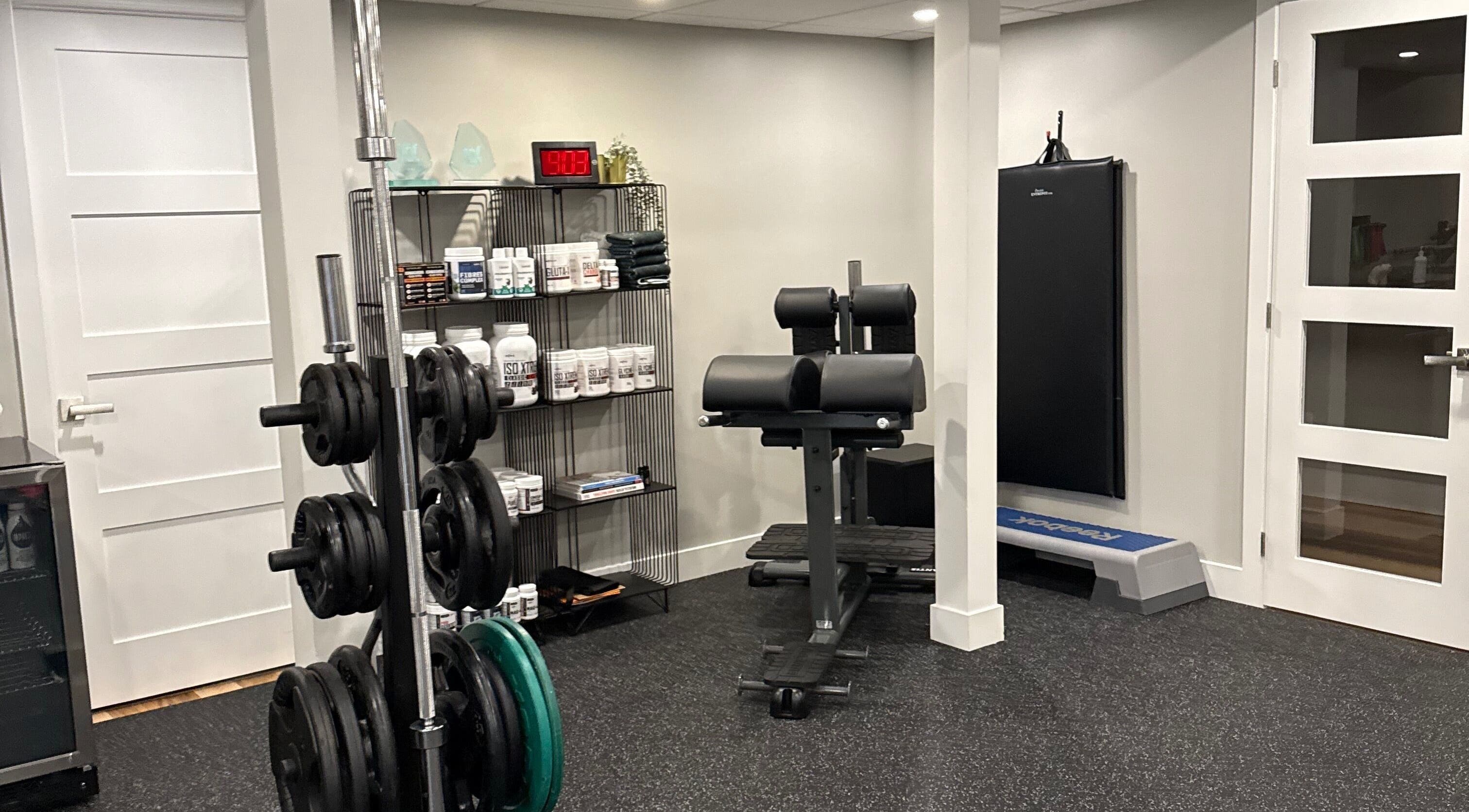 Gym area at Live avec Sylvia in Québec, CA featuring equipment and supplements for wellness.