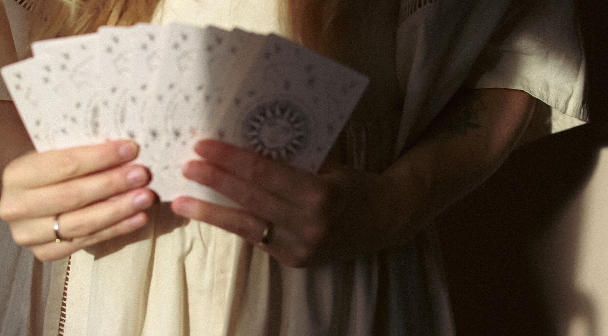 Handen met kaarten bij Zenspace in Enkhuizen, Noord-holland, NL, symboliseren mystieke en serene sfeer.