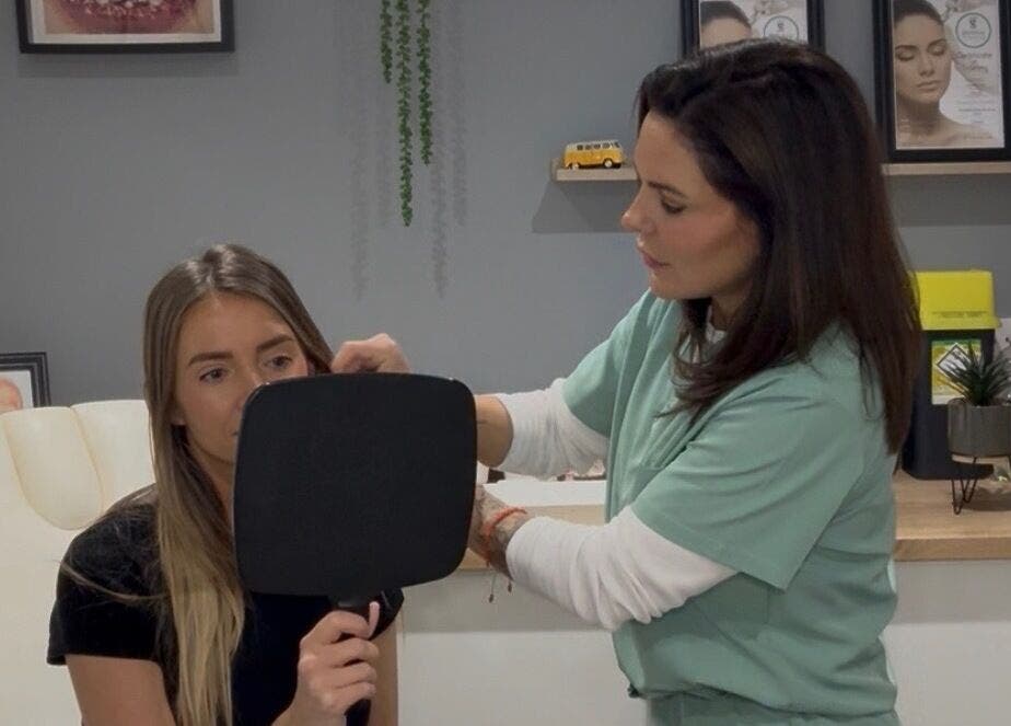 Expert consultation at JDL Aesthetics in Whitley Bay, England, GB with a patient holding a mirror.
