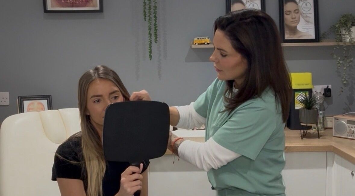 Expert consultation at JDL Aesthetics in Whitley Bay, England, GB with a patient holding a mirror.