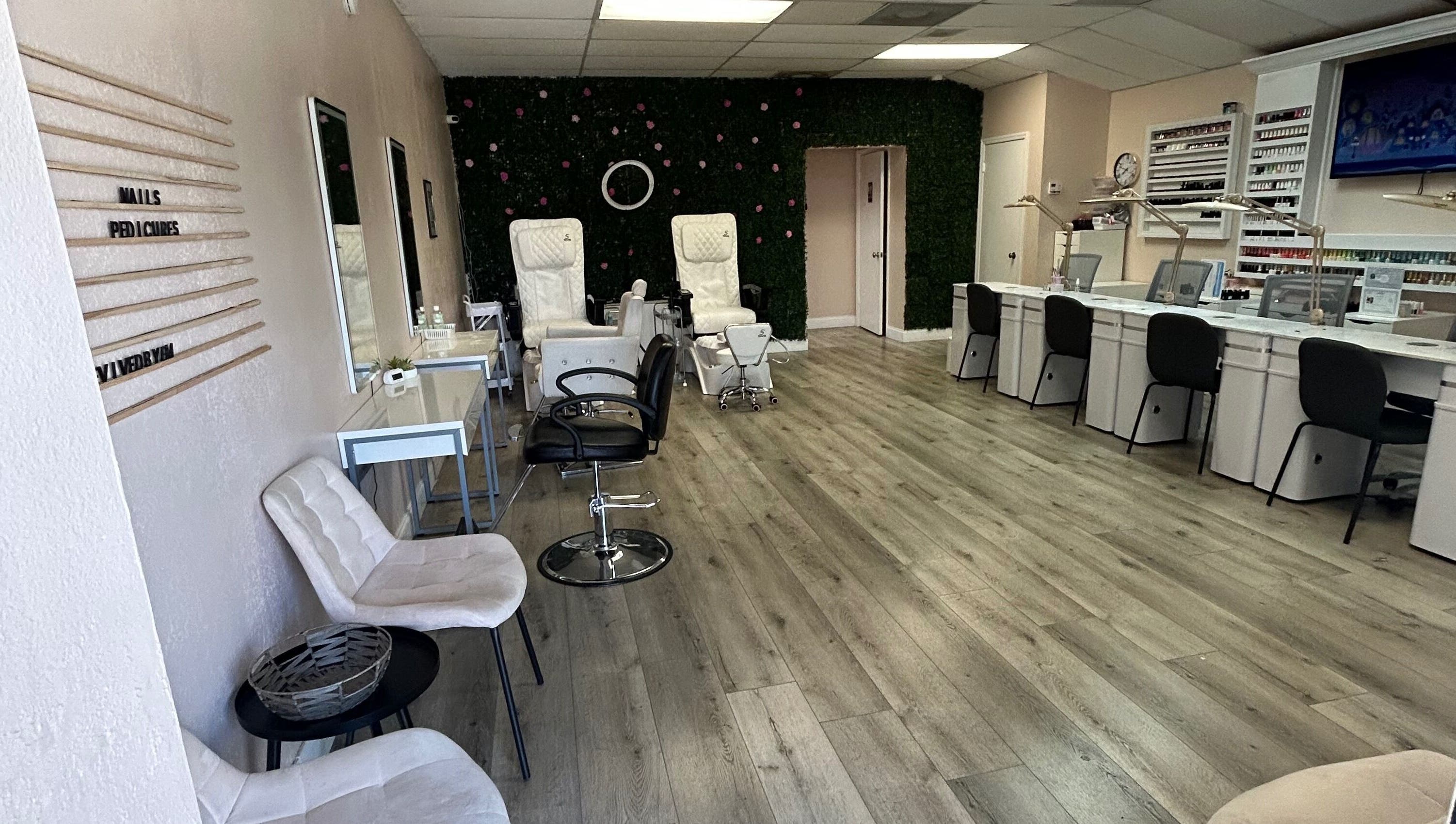 Revived By Emz Llc's stylish nail salon interior in Orlando, Florida, US, featuring white chairs and modern decor.