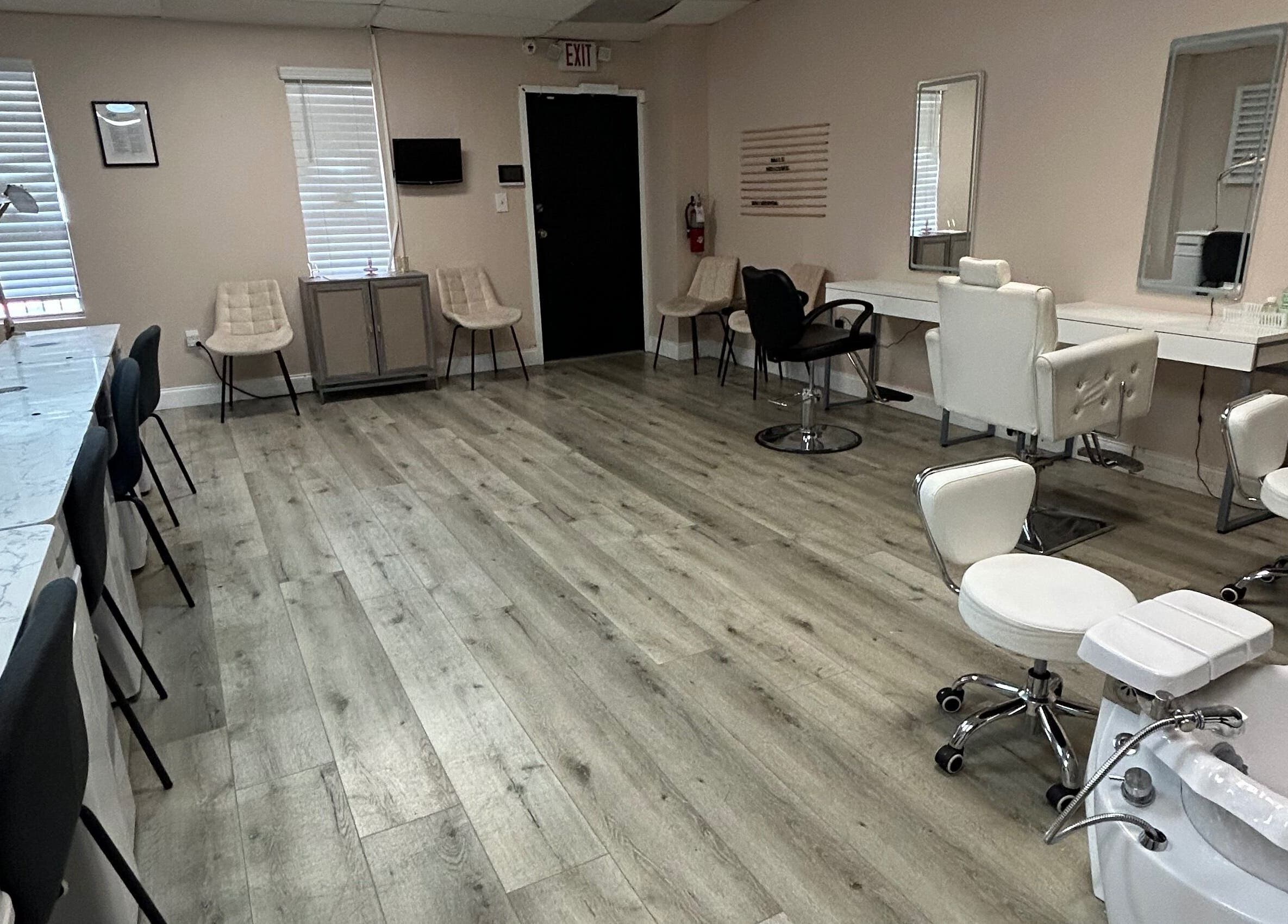 Spacious salon interior at Revived By Emz LLC, Orlando, Florida, US, featuring stylish chairs and workstations.