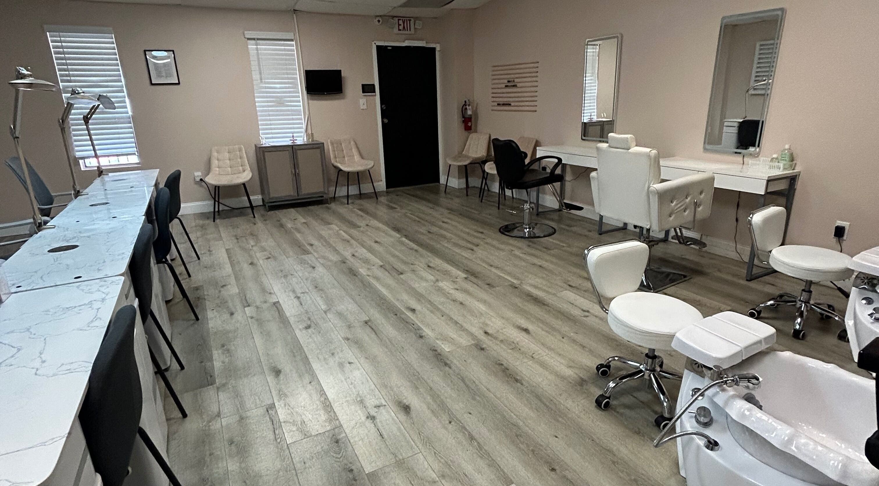 Spacious salon interior at Revived By Emz LLC, Orlando, Florida, US, featuring stylish chairs and workstations.