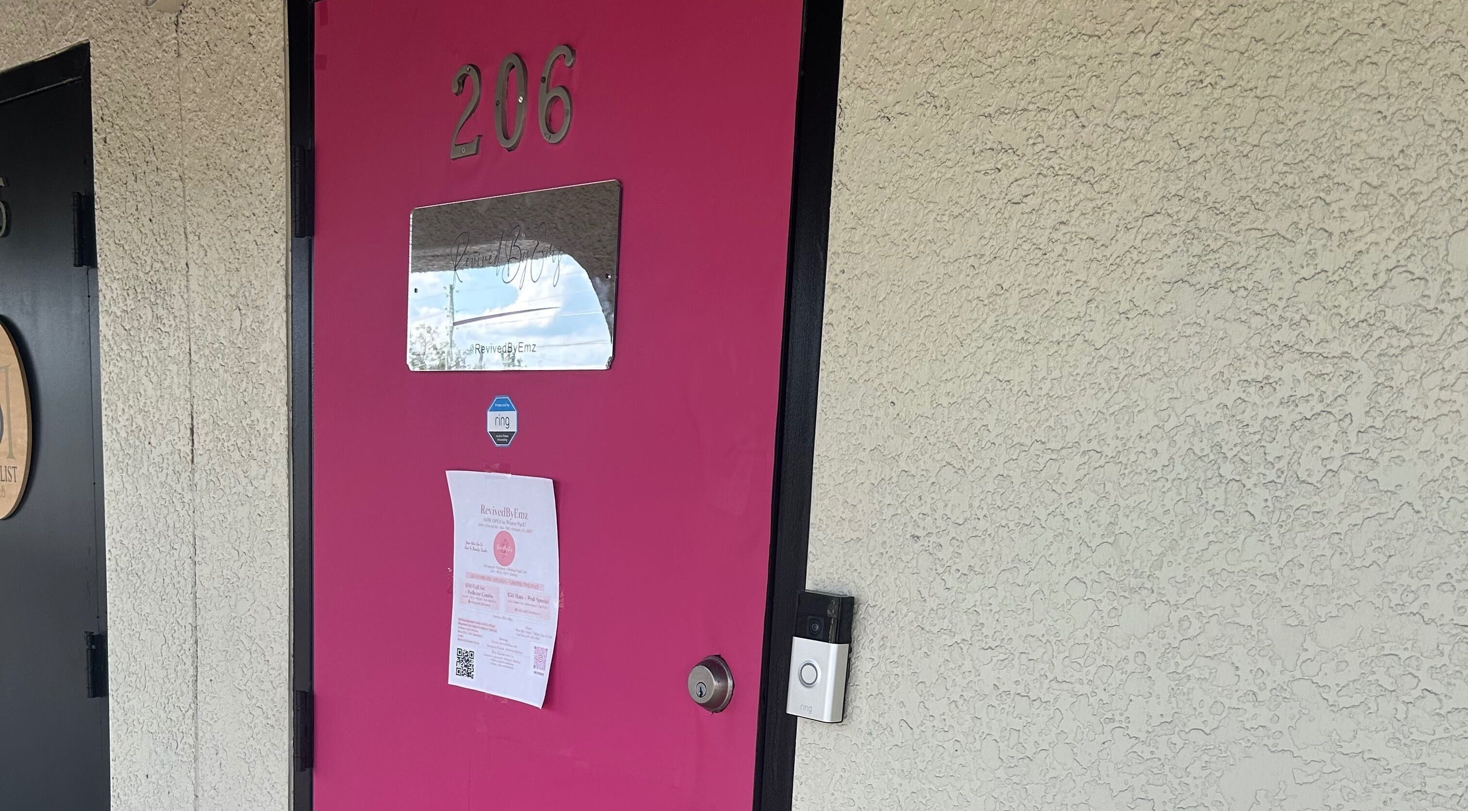 Bright pink door with suite 206 at Revived By Emz Llc, Orlando, Florida, US.