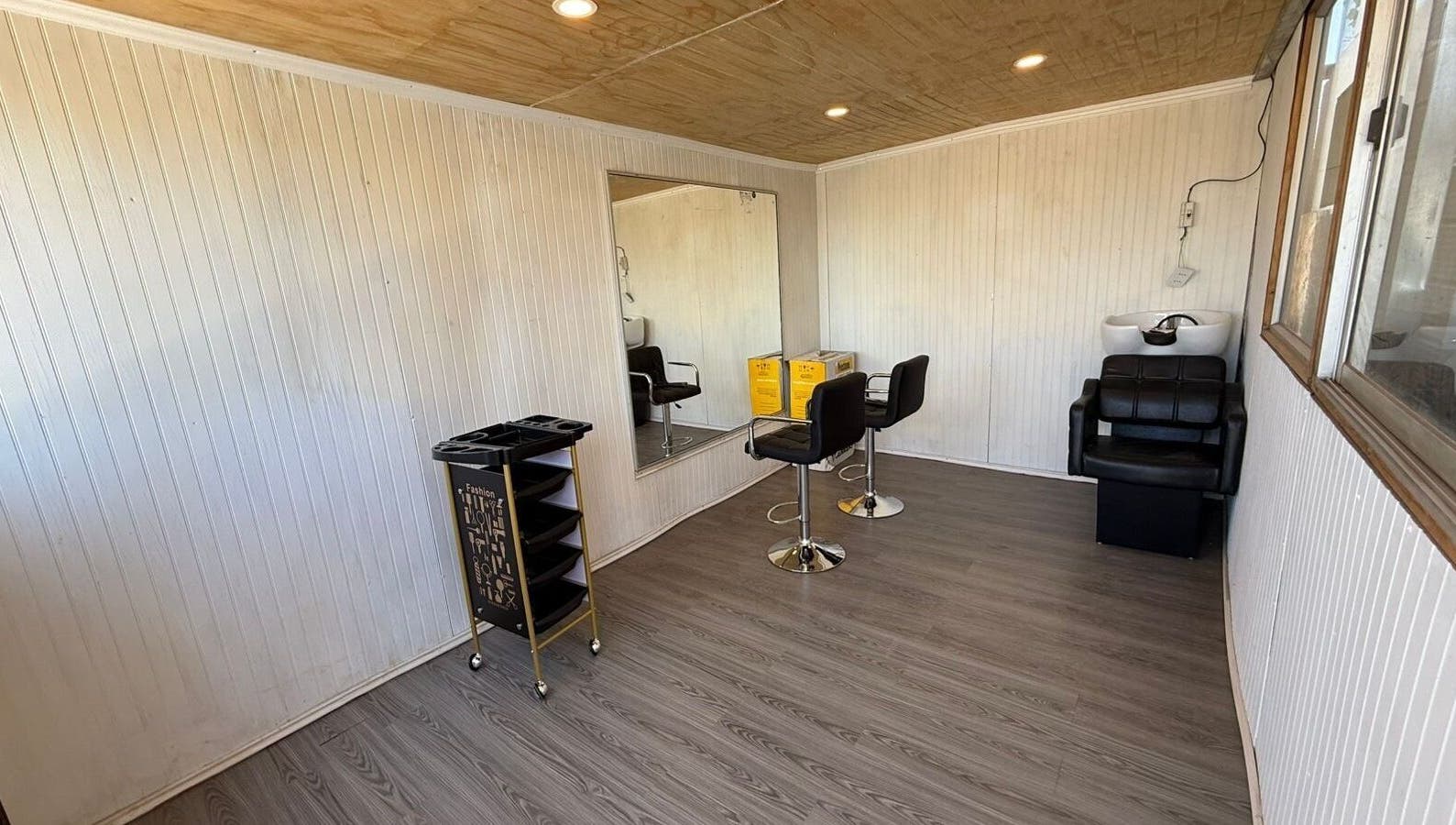 Interior de Nickbarberstudy en Santiago, Región Metropolitana, CL con sillas de estilismo y espejo.