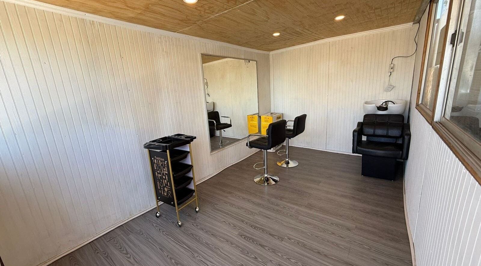 Interior de Nickbarberstudy en Santiago, Región Metropolitana, CL con sillas de estilismo y espejo.