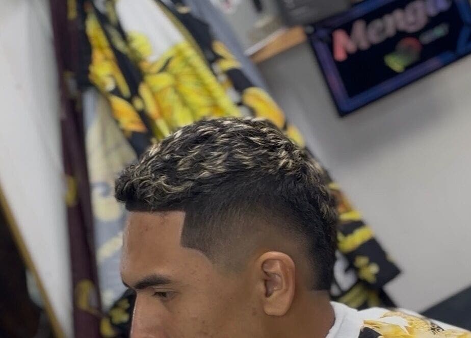 Coiffure fraîchement coupée chez Brizzy Barber à Papeete, Tahiti, PF, mettant en valeur des mèches blondes.