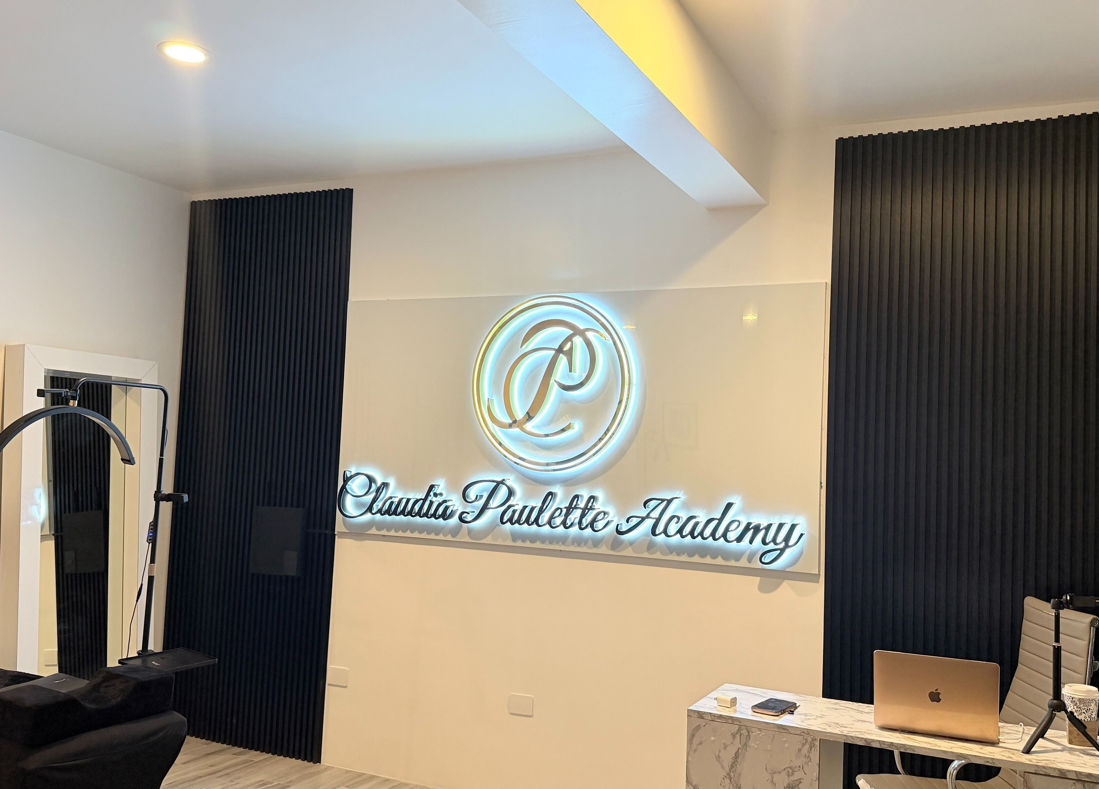 Interior moderno de Claudia Paulette Academy en Tijuana, Baja California, MX con su logo iluminado.