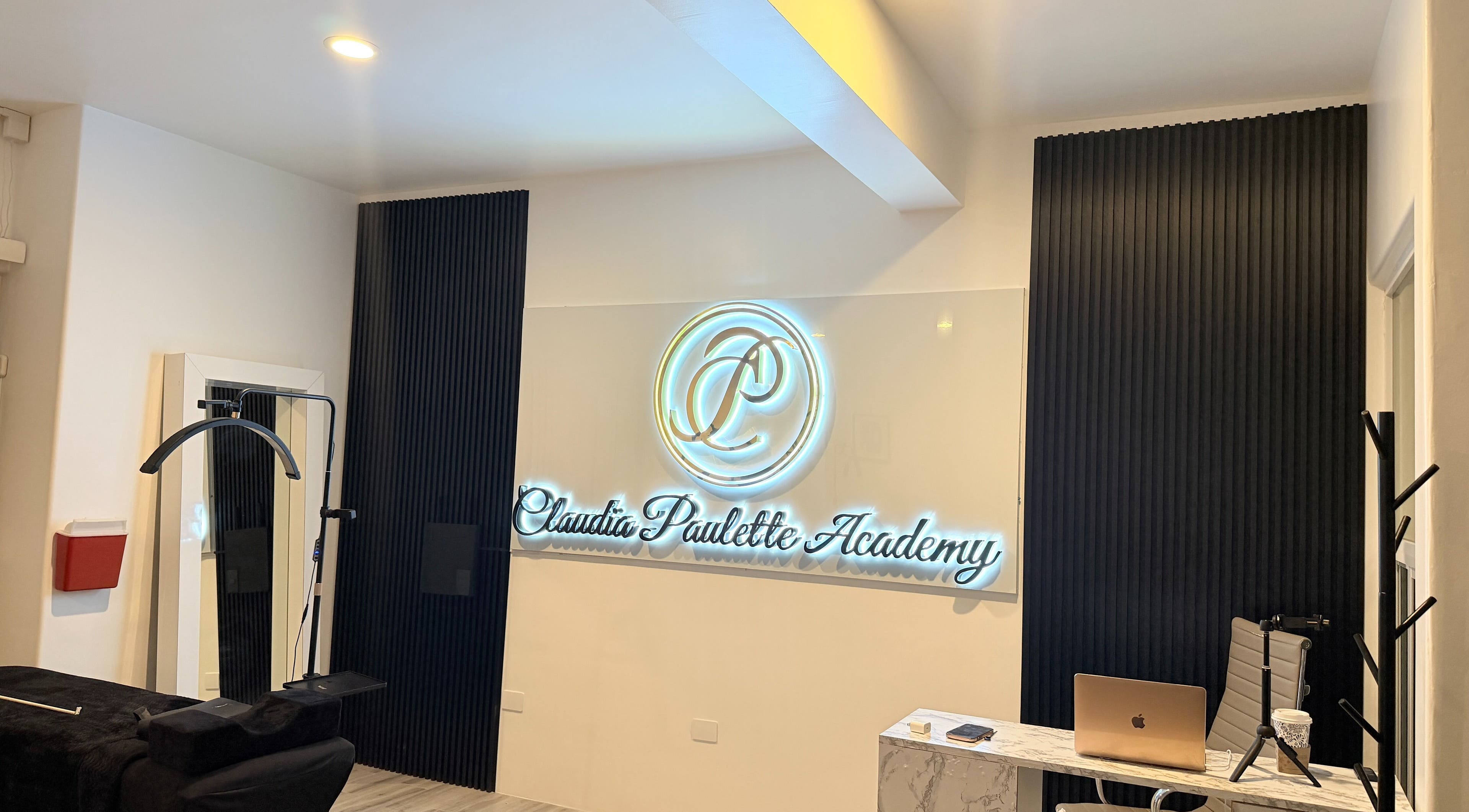 Interior moderno de Claudia Paulette Academy en Tijuana, Baja California, MX con su logo iluminado.