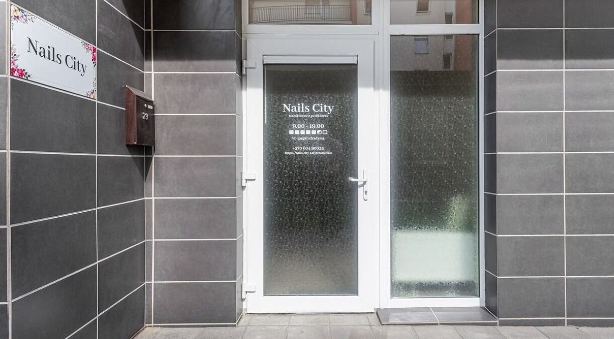 Nagai Miesto Vilnius įėjimas su elegantiškomis durimis ir keraminėmis plytelėmis.