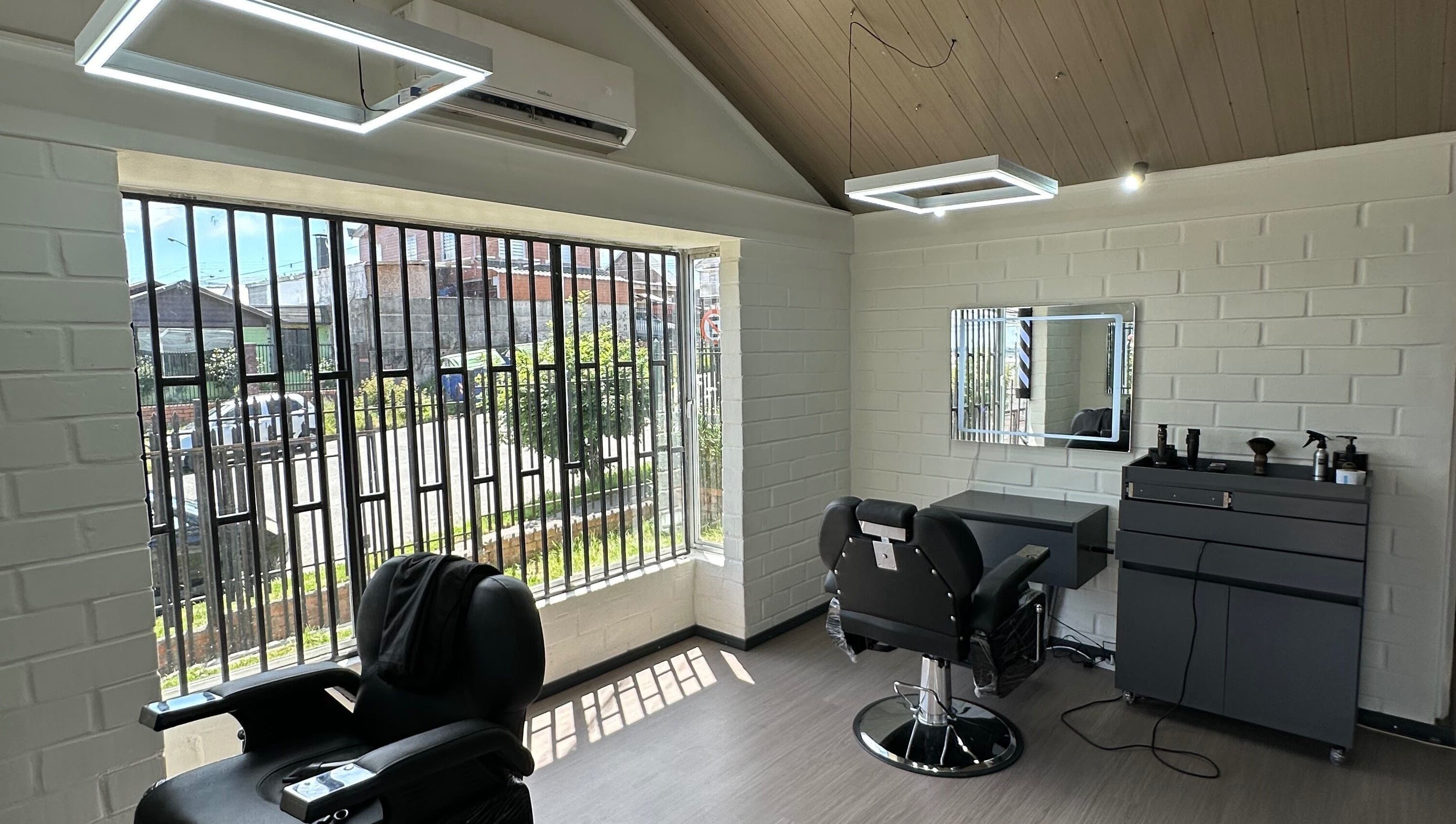 Interior moderno de FORJA STUDIO en Puerto Montt, Los Lagos, CL con sillas de peluquería y grandes ventanas.