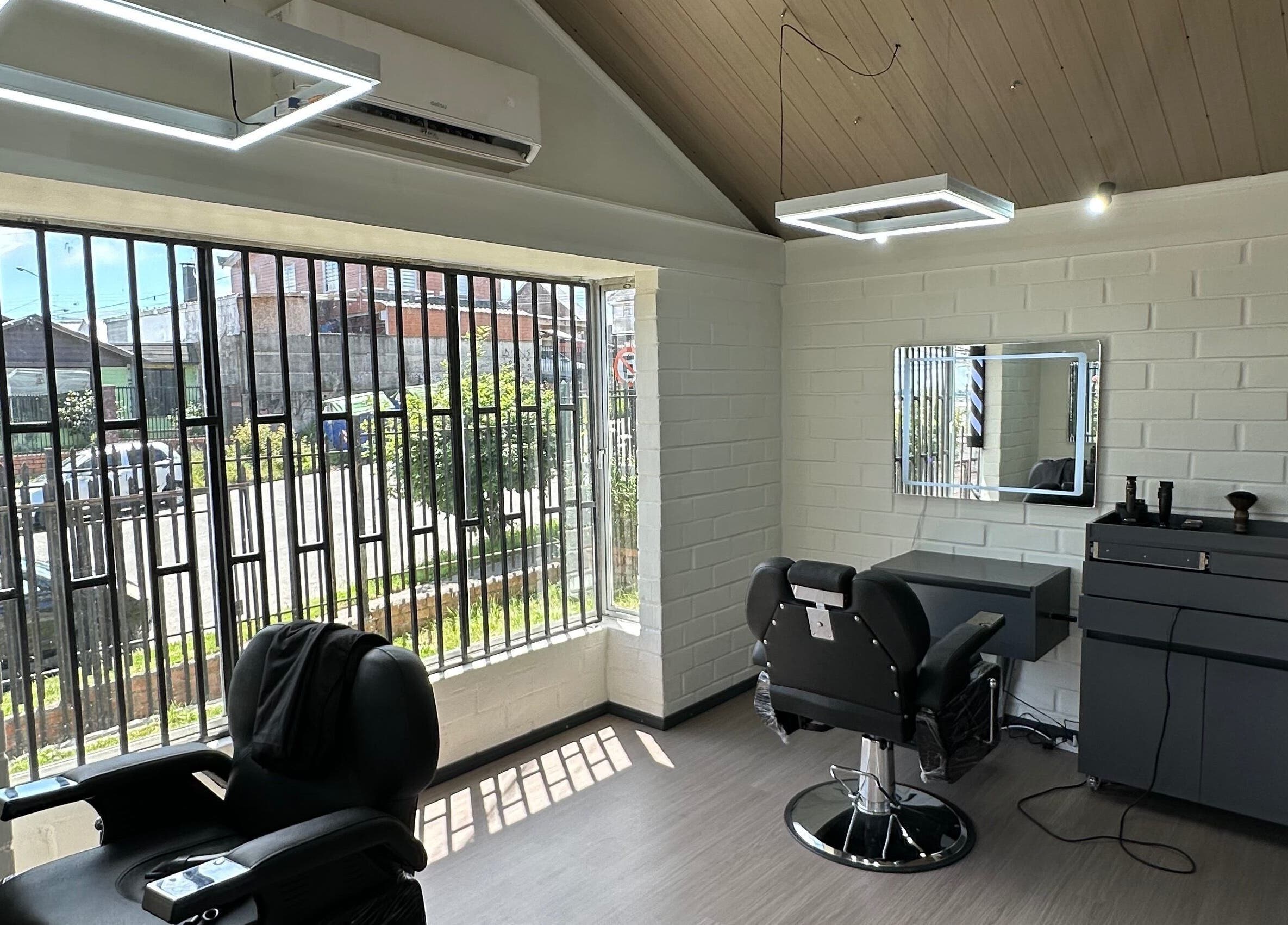 Interior moderno de FORJA STUDIO en Puerto Montt, Los Lagos, CL con sillas de peluquería y grandes ventanas.