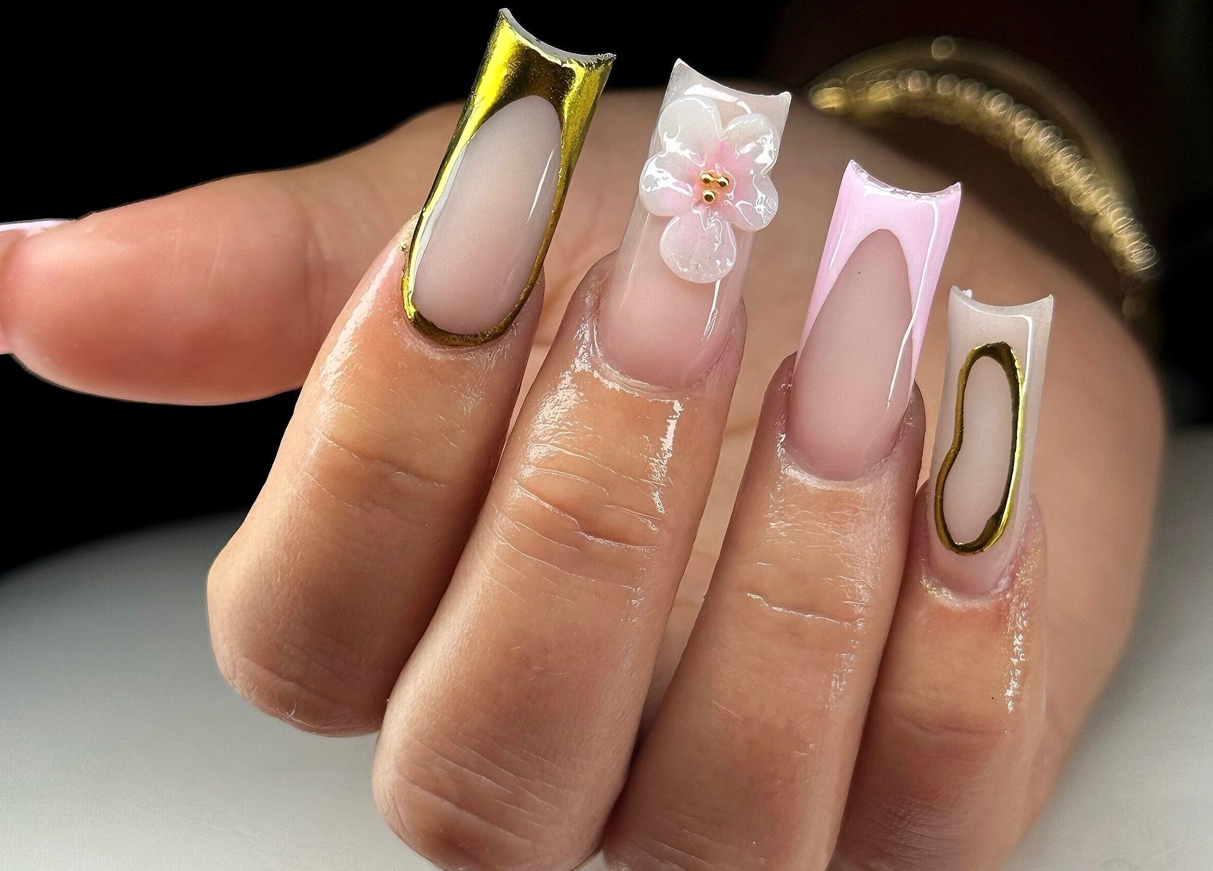 Intricate nail art design at Leasnailhub, Peterborough, England, GB showcasing detailed gold and floral accents.