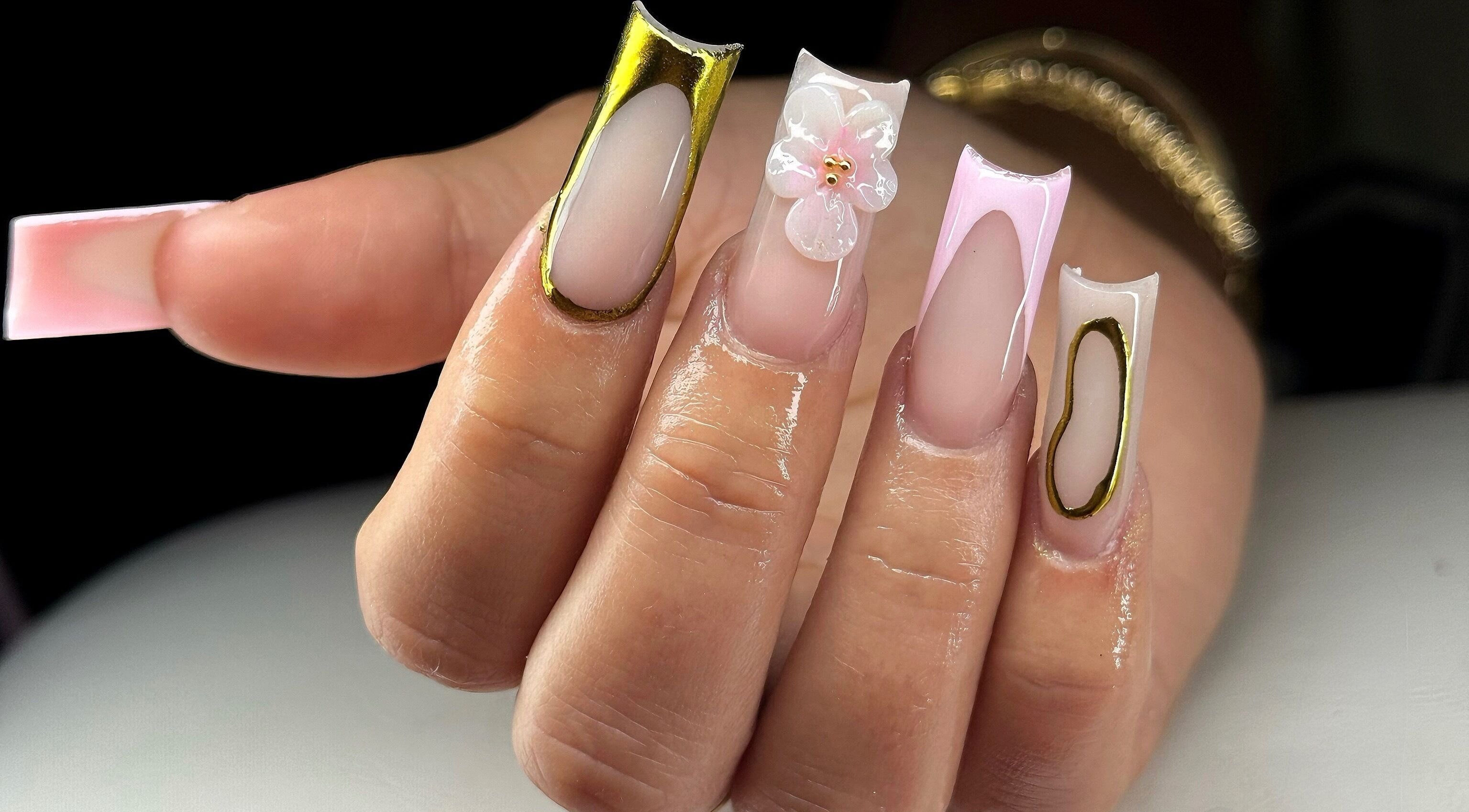 Intricate nail art design at Leasnailhub, Peterborough, England, GB showcasing detailed gold and floral accents.