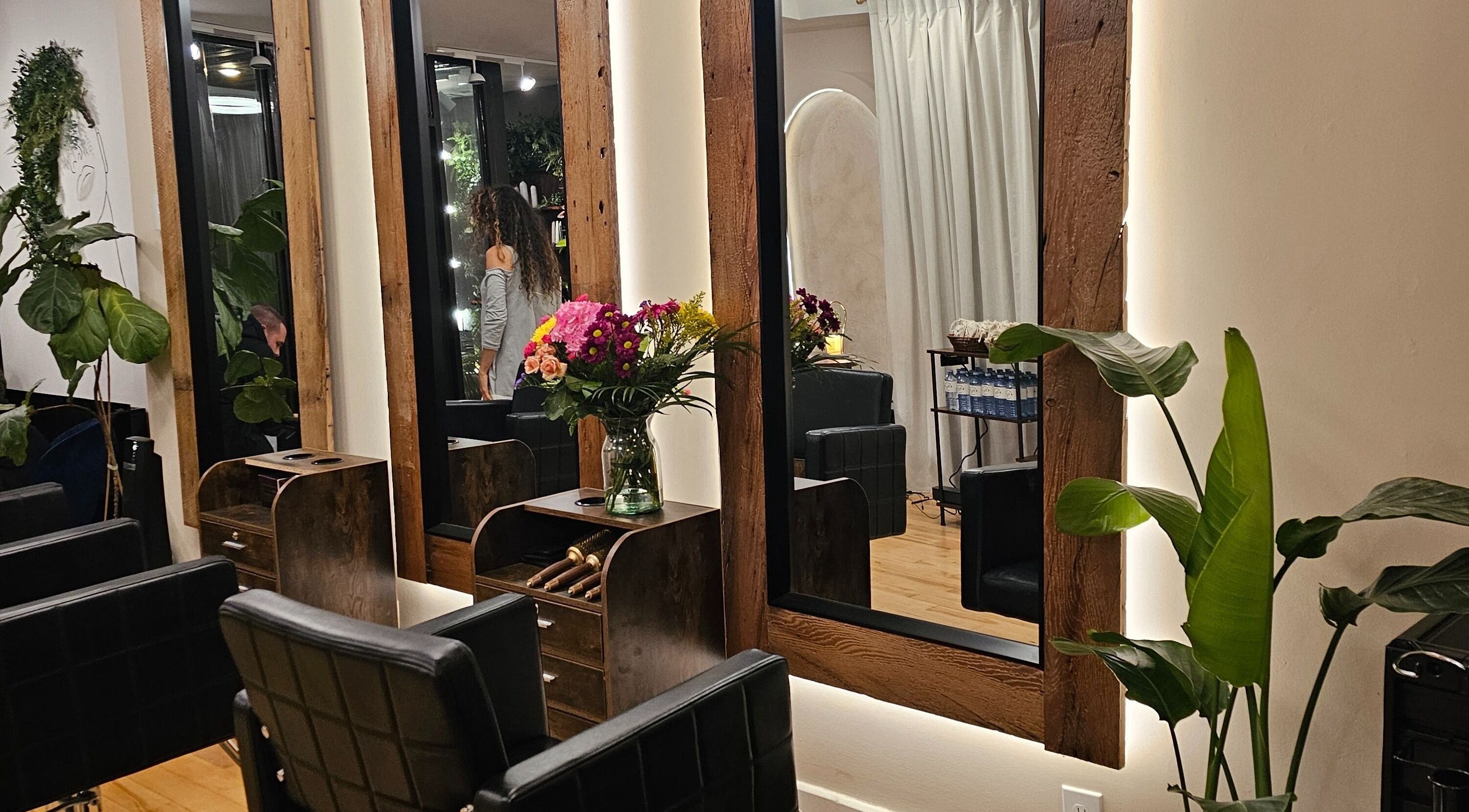 Sofisticado salón de belleza en Éclat Naturel studio INC, Montreal, Québec, CA con sillas de cuero y plantas.