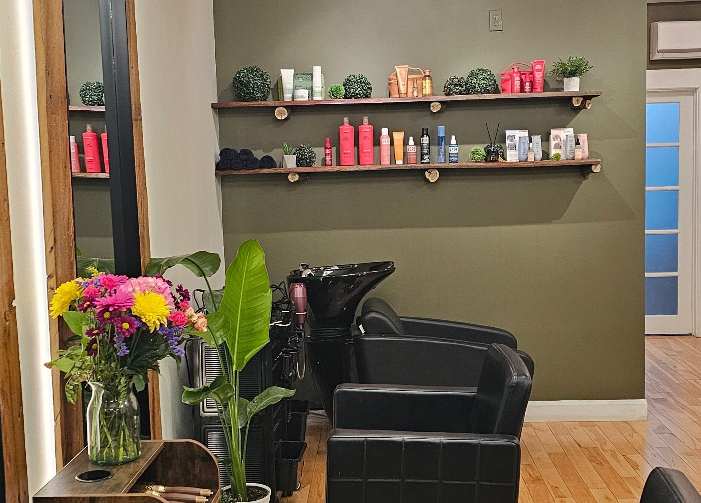 Interior del Éclat Naturel studio INC en Montréal, Québec, CA con sillas de salón y flores frescas.