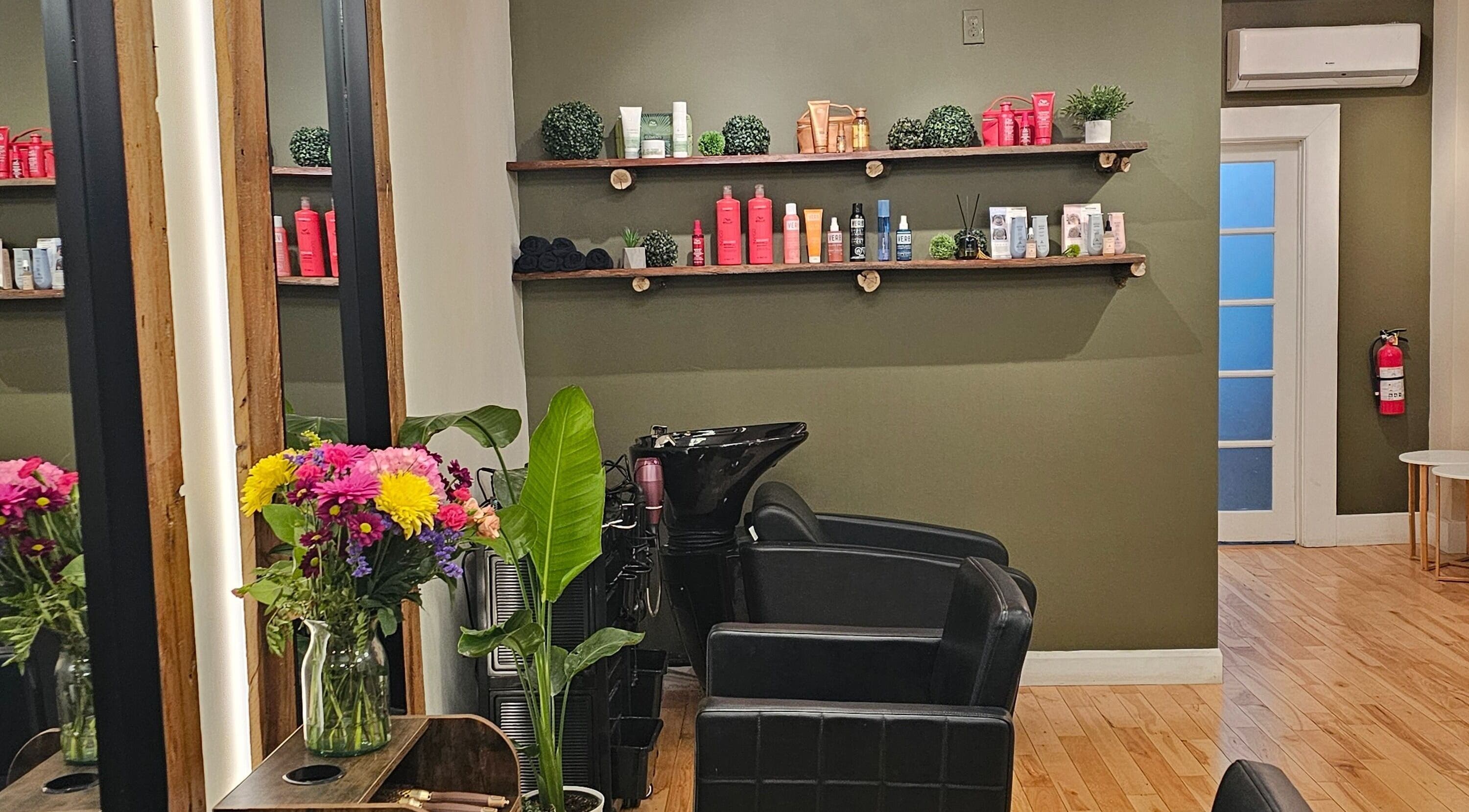Interior del Éclat Naturel studio INC en Montréal, Québec, CA con sillas de salón y flores frescas.