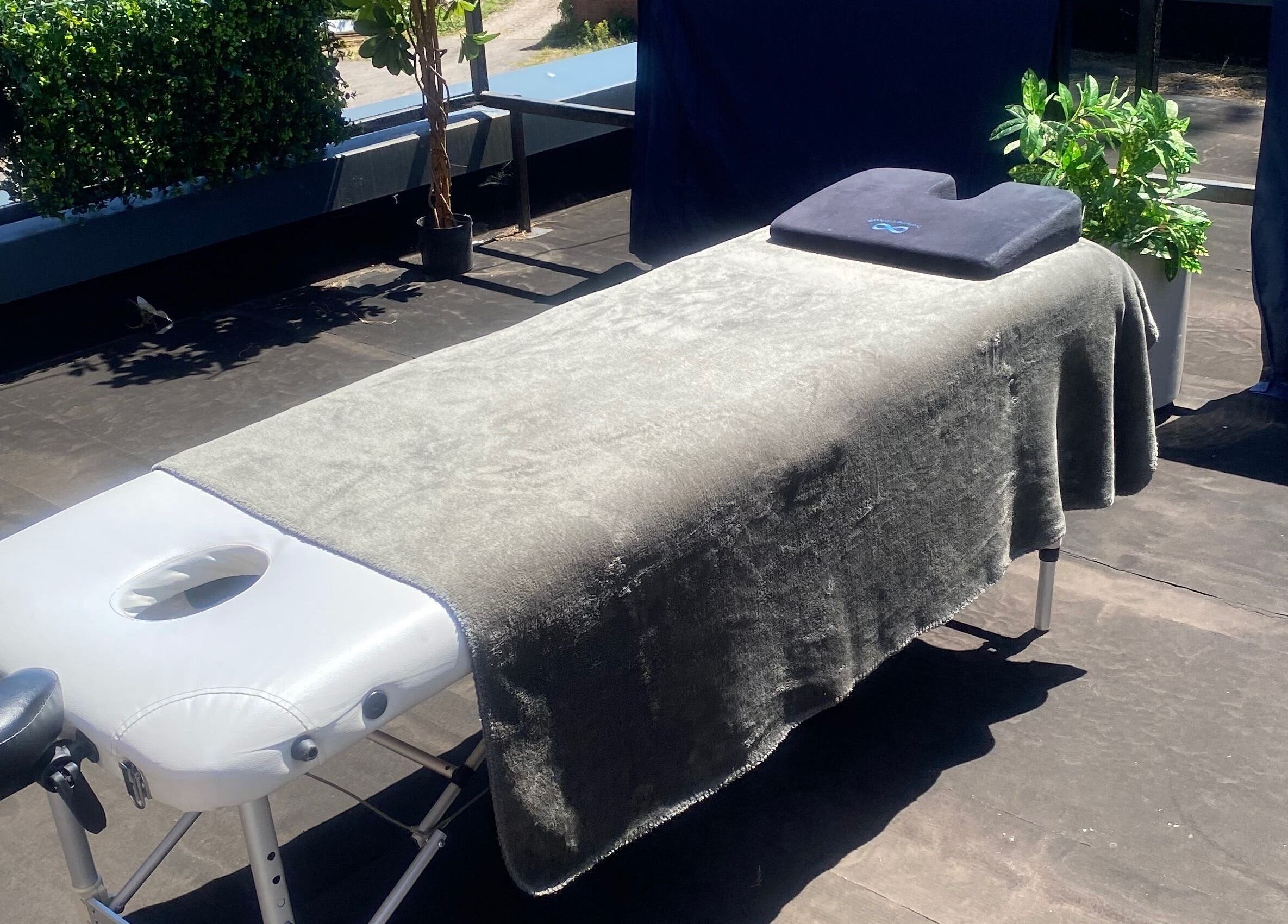 Outdoor massage table setup at 1stclass Massage, Sebastopol, Wales, GB, offering a serene relaxation space.