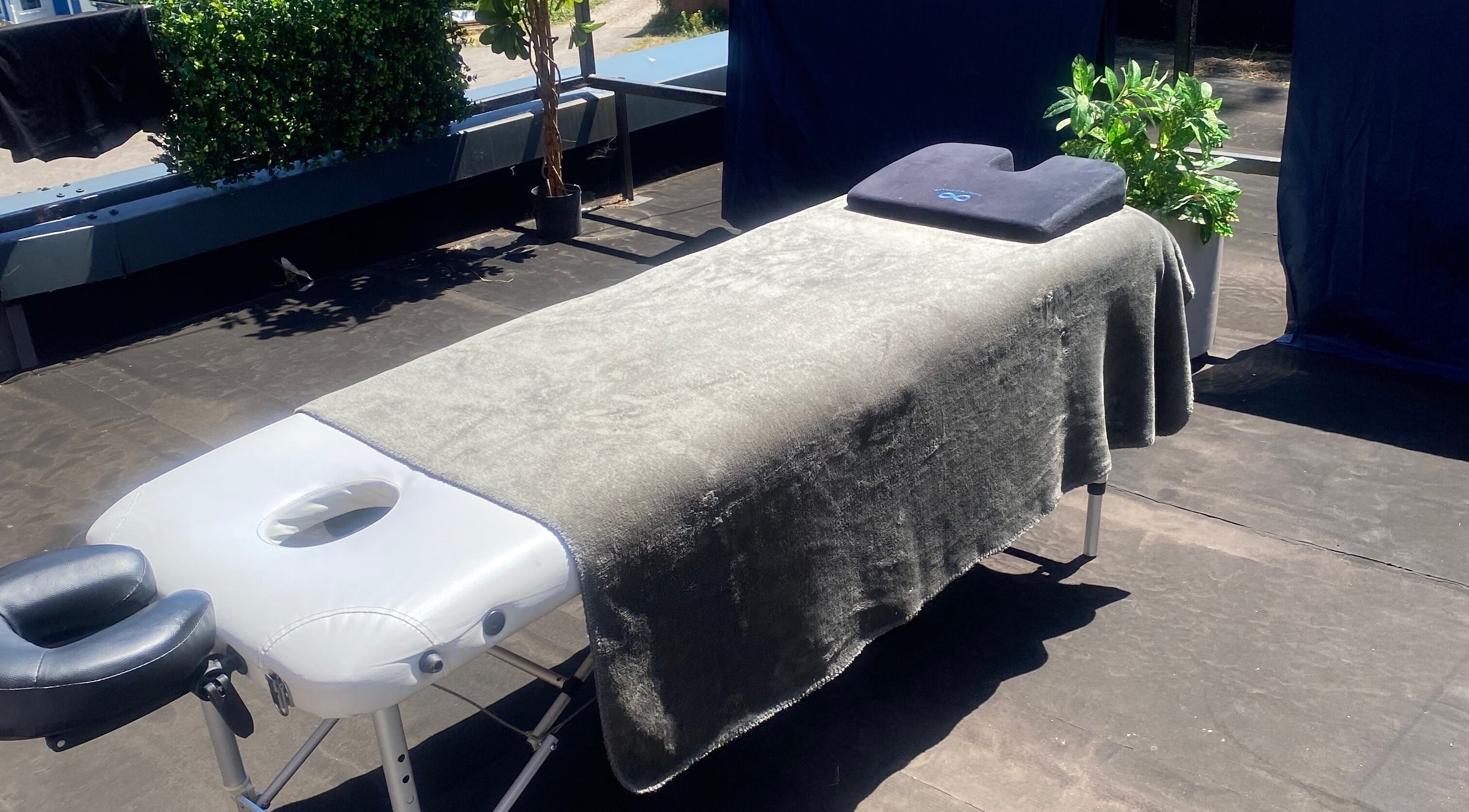 Outdoor massage table setup at 1stclass Massage, Sebastopol, Wales, GB, offering a serene relaxation space.