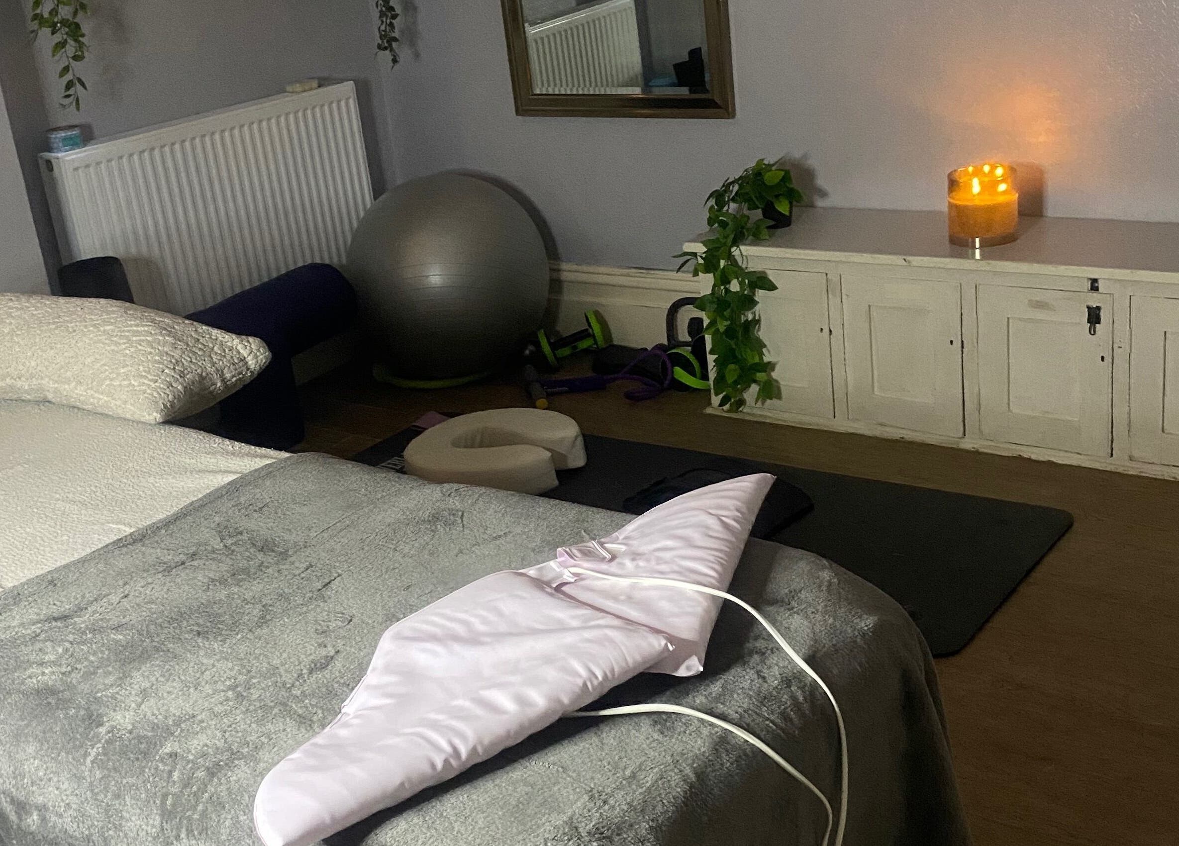 Peaceful massage room at 1stclass Massage, Sebastopol, Wales, GB, with cozy bed and calming candles.