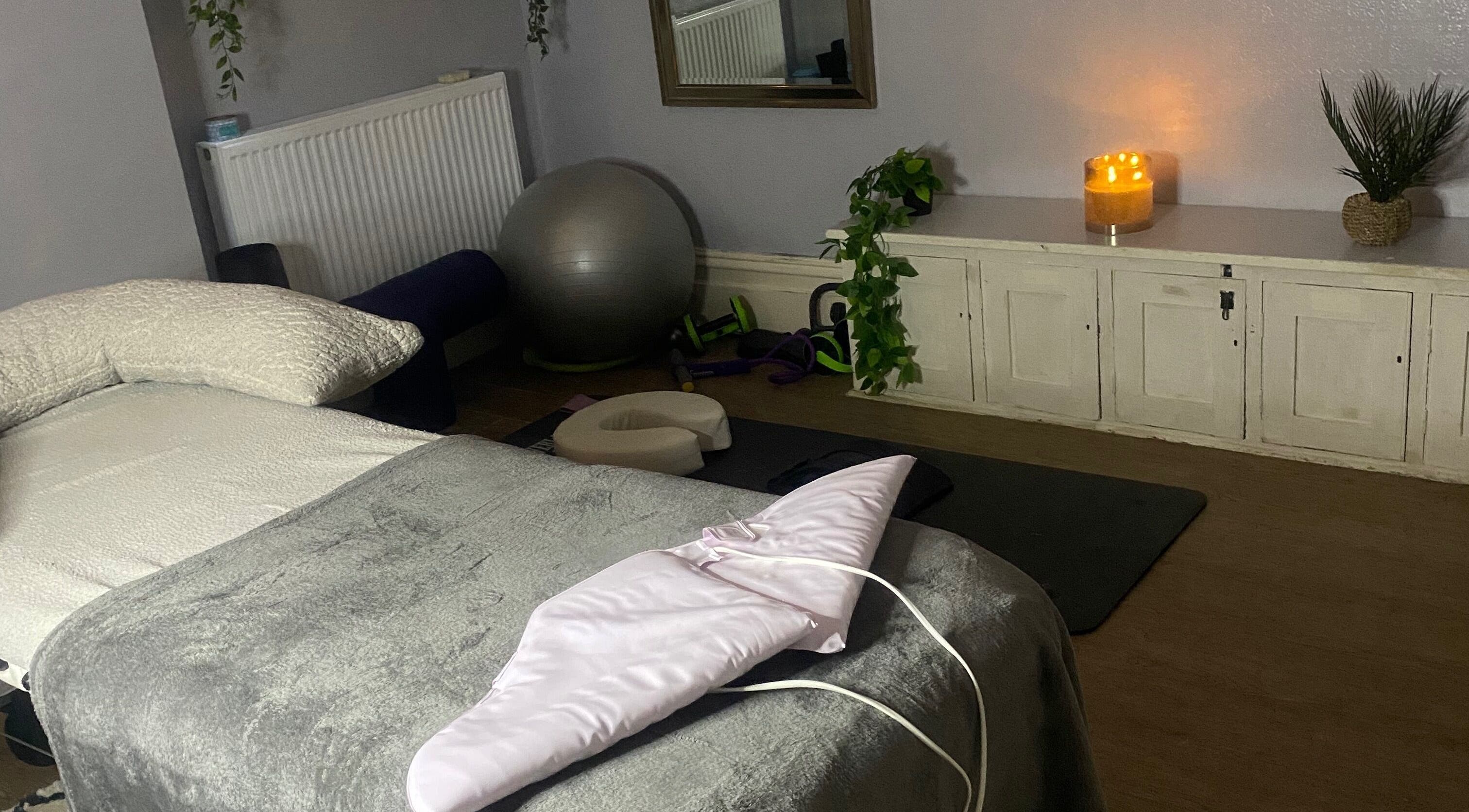 Peaceful massage room at 1stclass Massage, Sebastopol, Wales, GB, with cozy bed and calming candles.