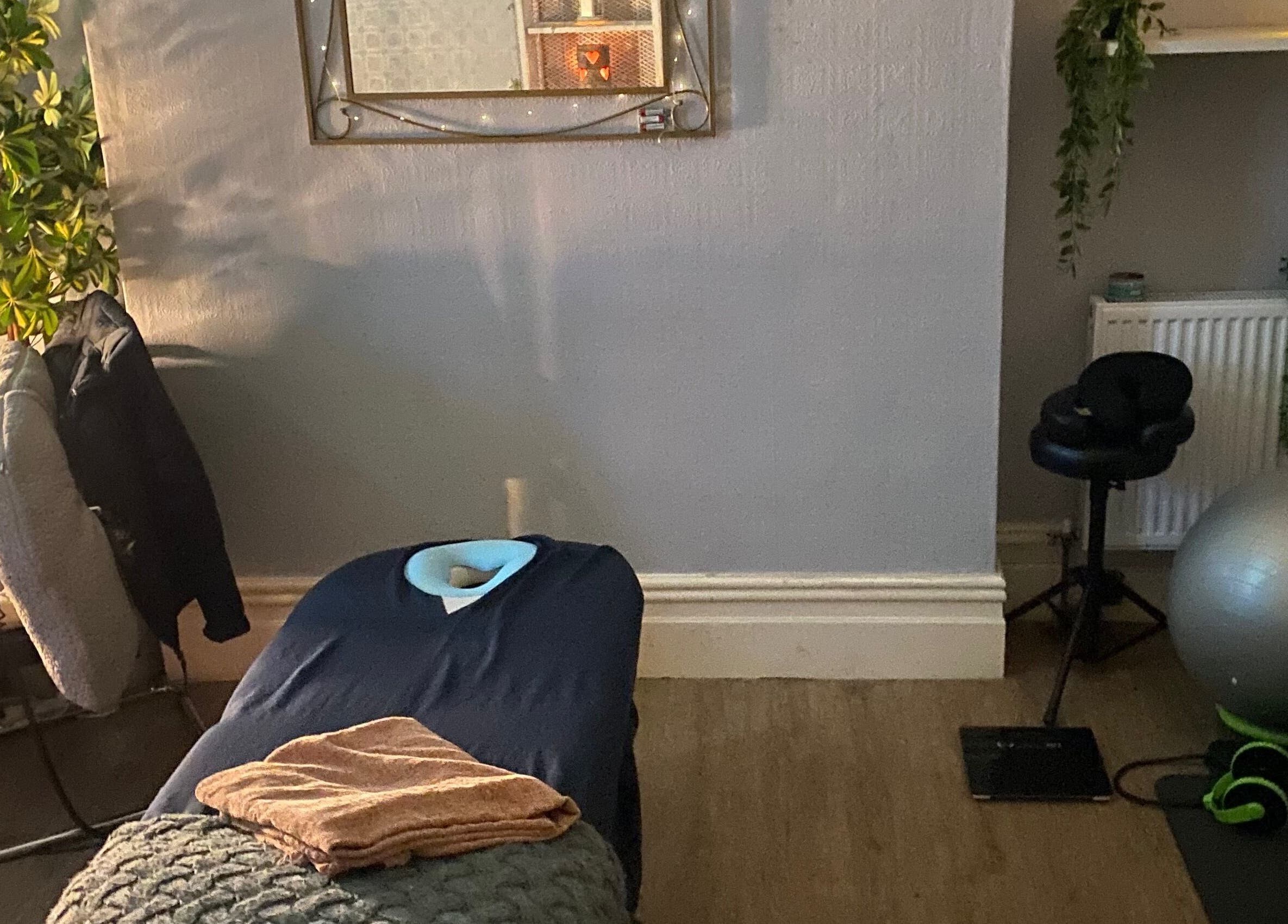 Cozy massage room at 1stclass Massage Sebastopol, Wales, GB with table and soothing decor.