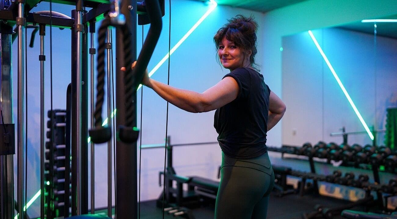 Vrouw traint bij Jouw Krachtstation in Bodegraven, Zuid-Holland, NL in een kleurrijke fitnessruimte.