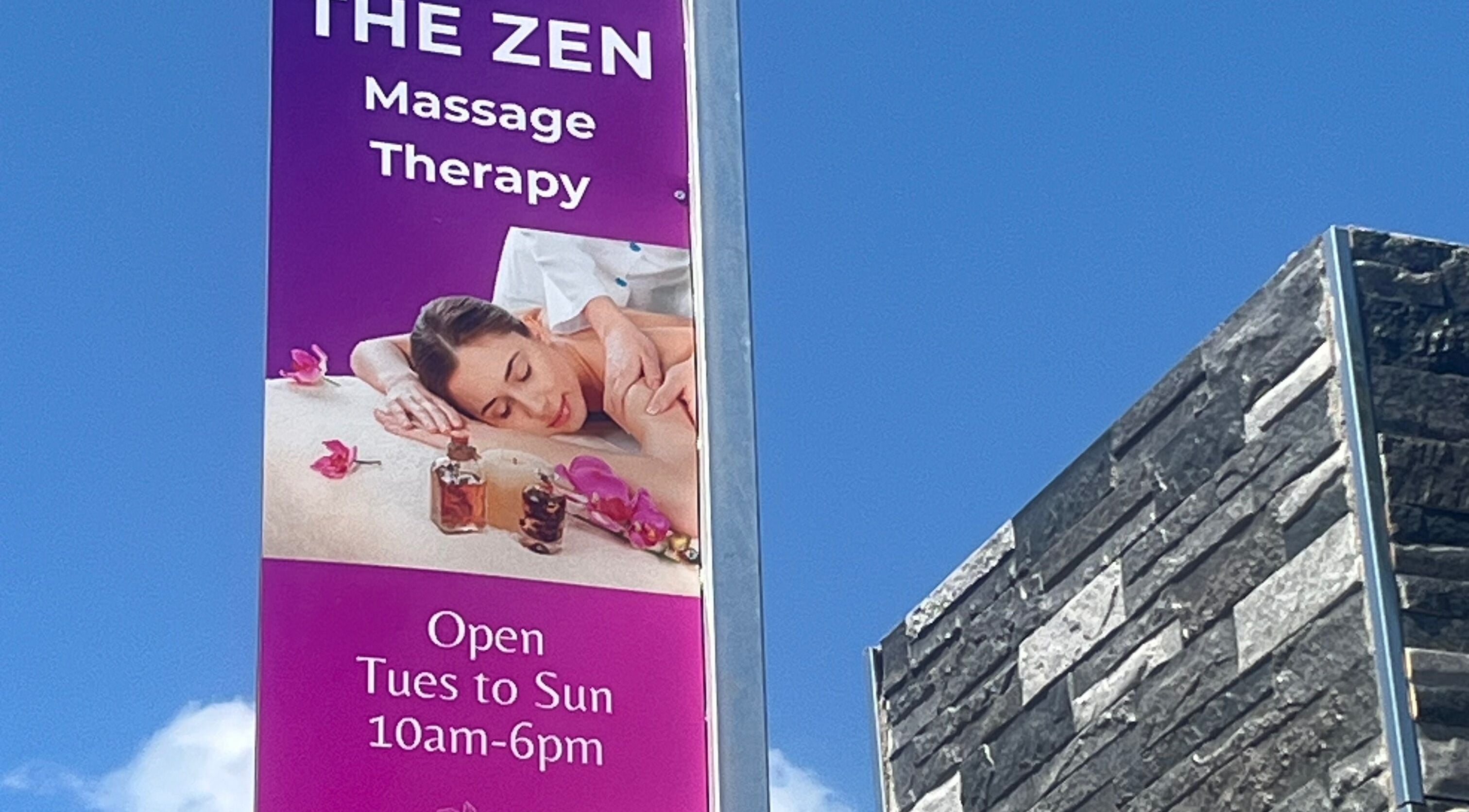 Sign for The Zen Spa offering massage therapy in Queensburgh, Kwazulu-natal, ZA under a clear blue sky.