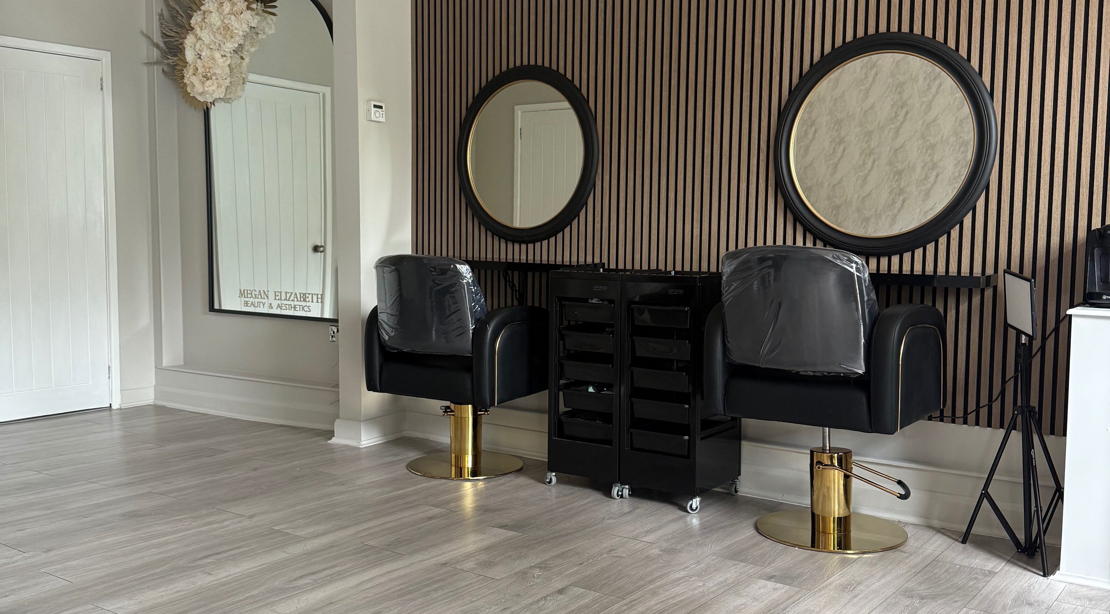 Elegant styling chairs at Megan Elizabeth Beauty & Aesthetics, Birmingham, England, GB with mirrors on a striped wall.